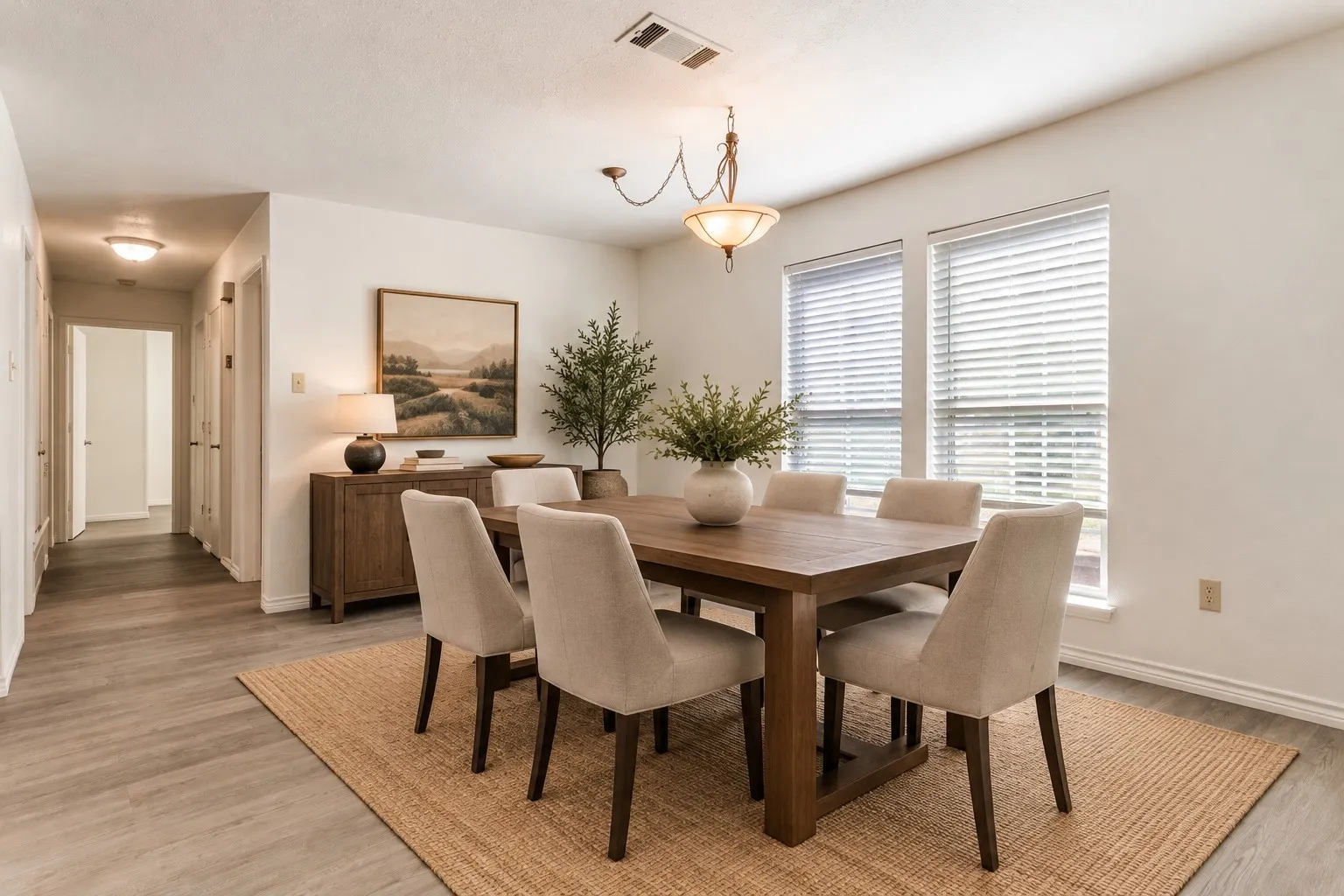 Dining area with wood-finish flooring, recessed lighting, and a hanging decorative light fixture; virtually staged