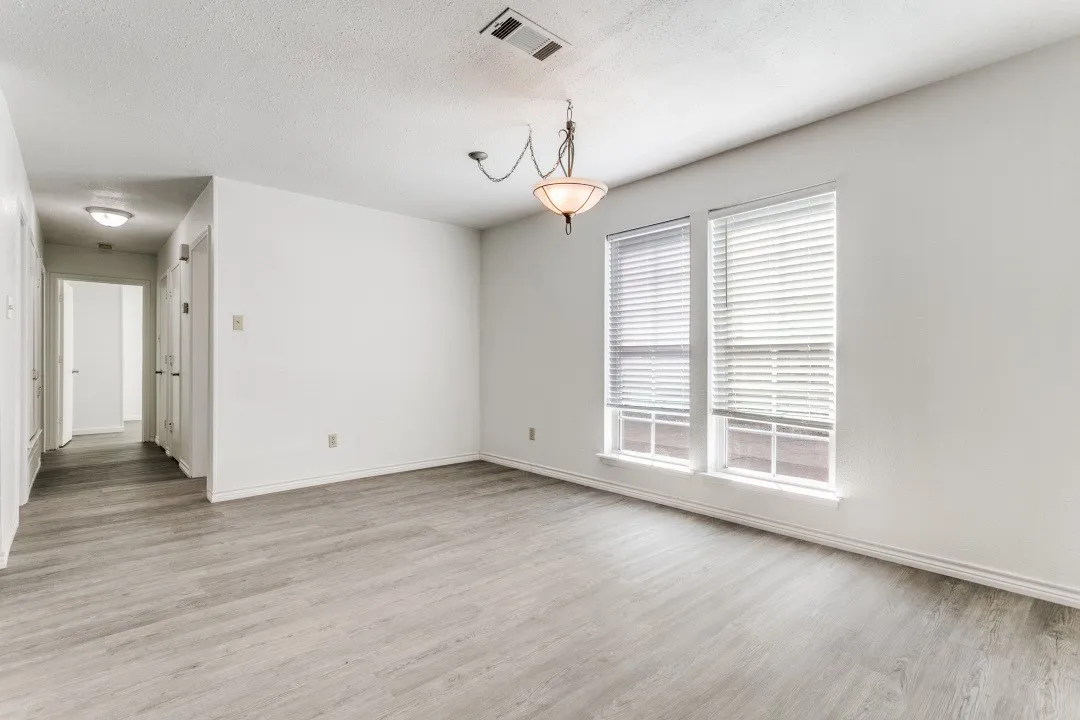 Spacious interior with light wood-finish flooring, white walls, and white baseboards