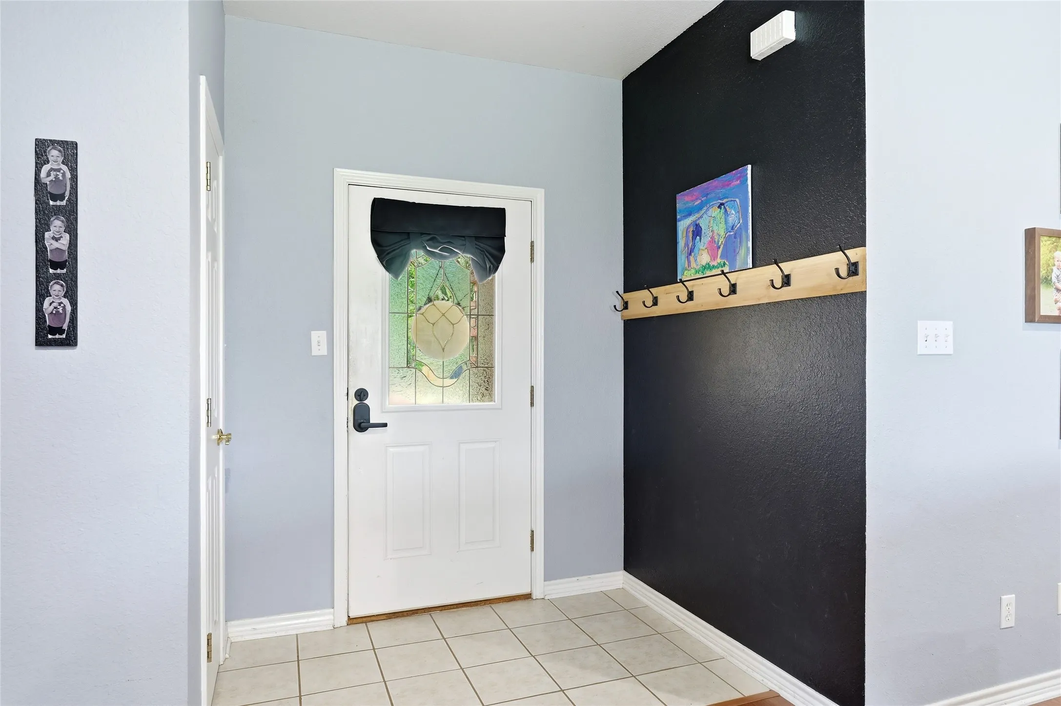 Entryway featuring a white paneled door with decorative glass insert