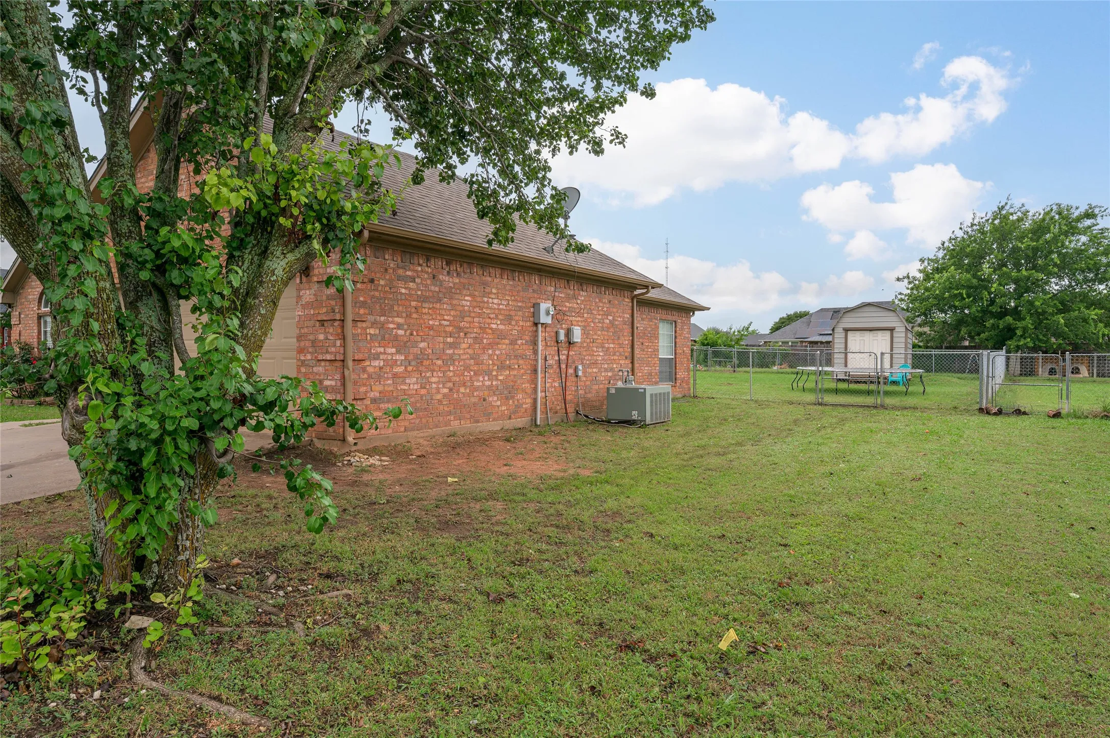 Expansive green lawn with a chain-link fence enclosing the property