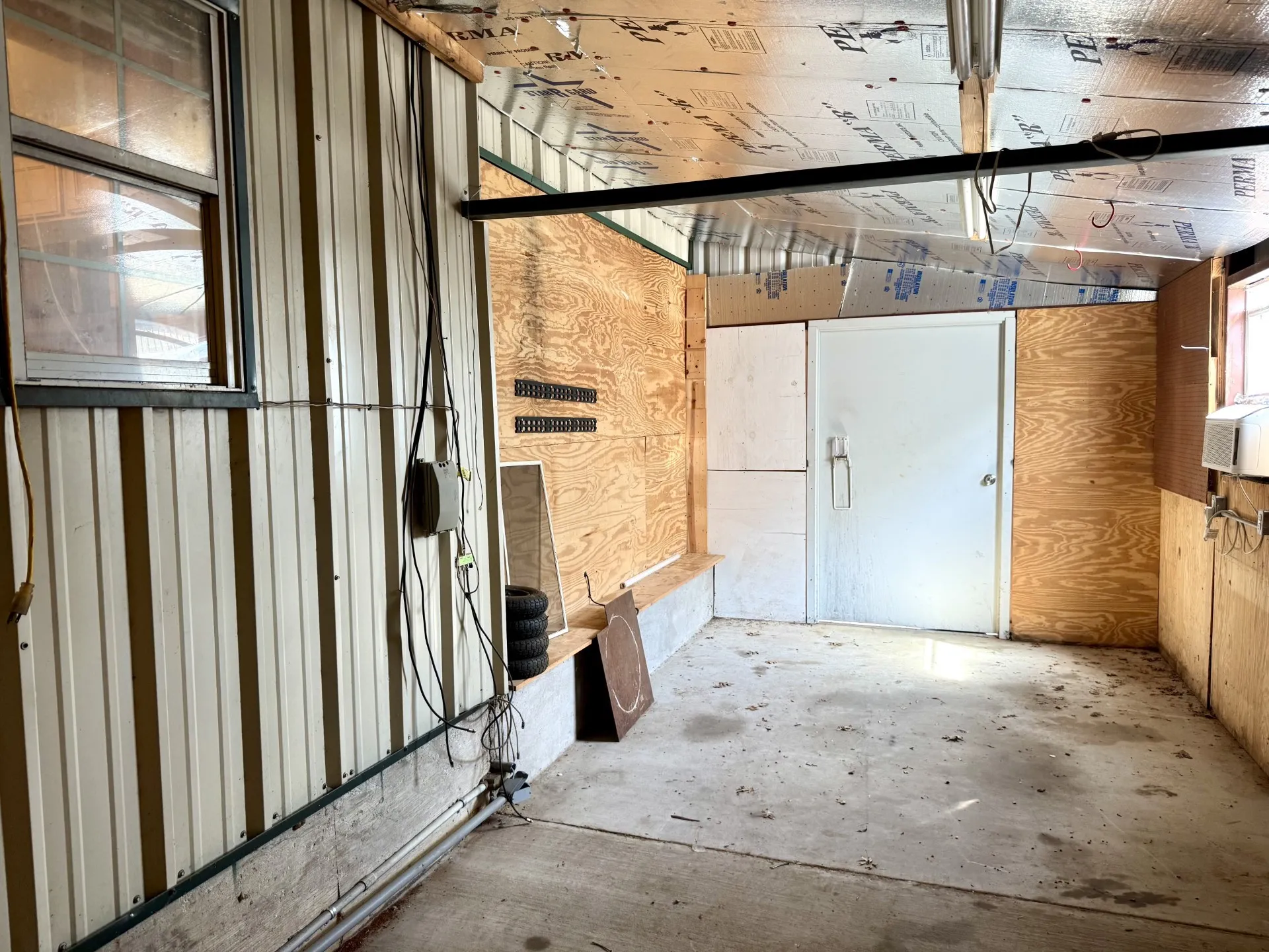 22x10 Workshop features a concrete floor, plywood wall finishes, and a sheet metal exterior wall with an EXTERIOR DOOR too! Opens to Home and Outside :)