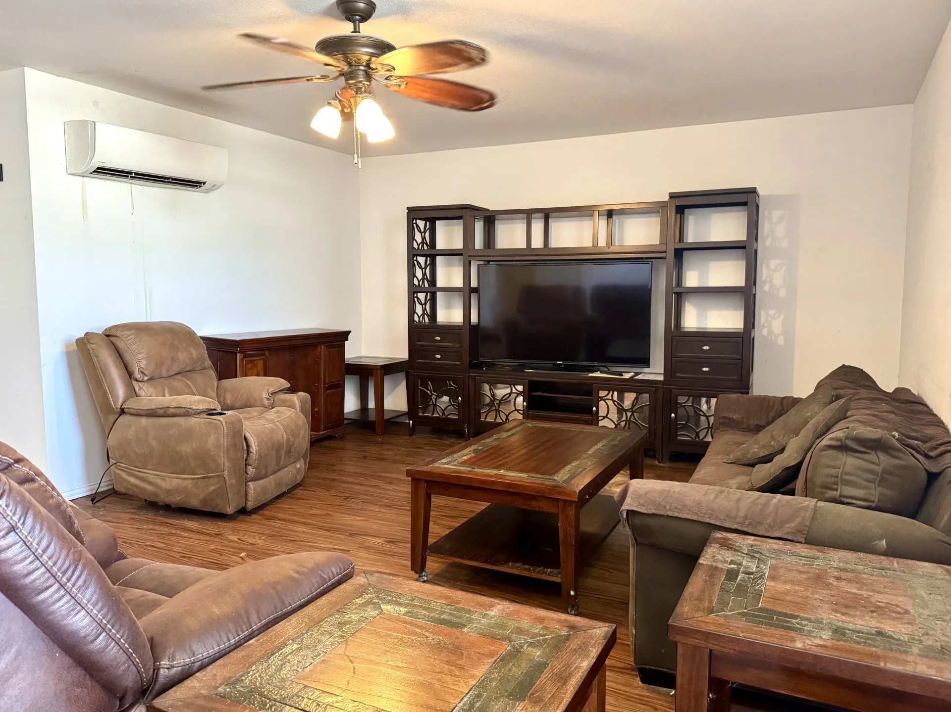 Spacious FRONT Living Room features wood-finish flooring, ceiling fan, and a wall-mounted mini-split unit