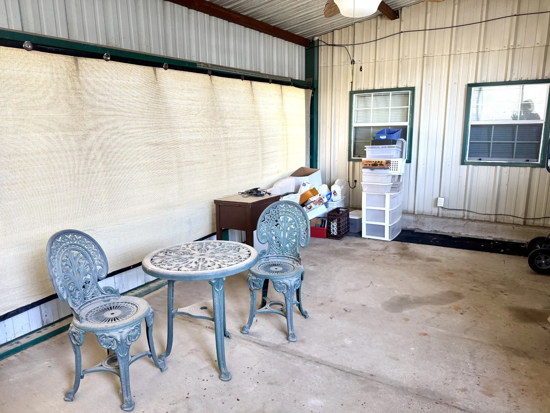 Enclosed Screened Patio Sunroom featuring a concrete floor, corrugated metal walls, and a translucent overhead screen