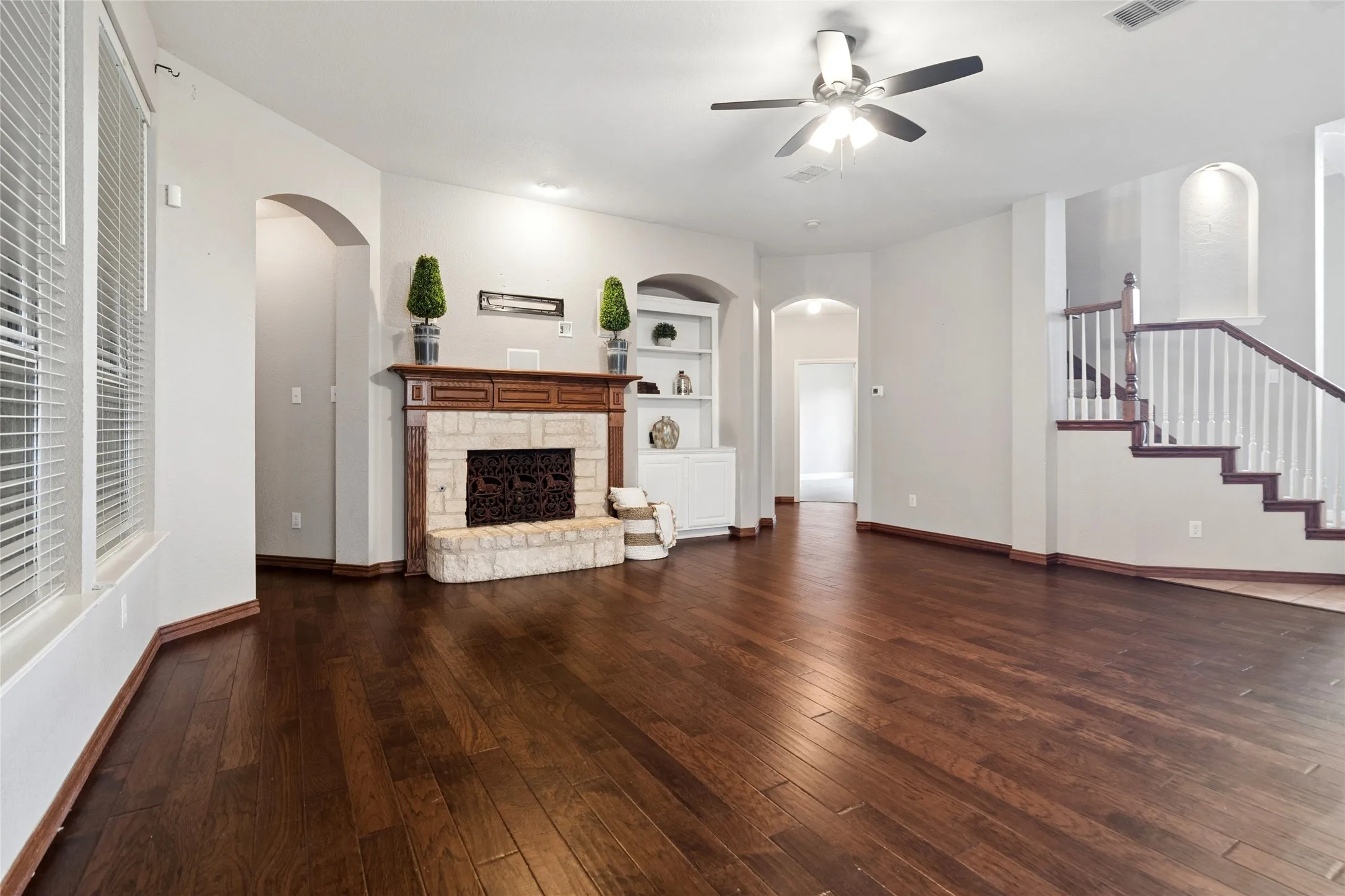 Family room with stone fireplace, gas starter,  built in shelving and surround sound speakers