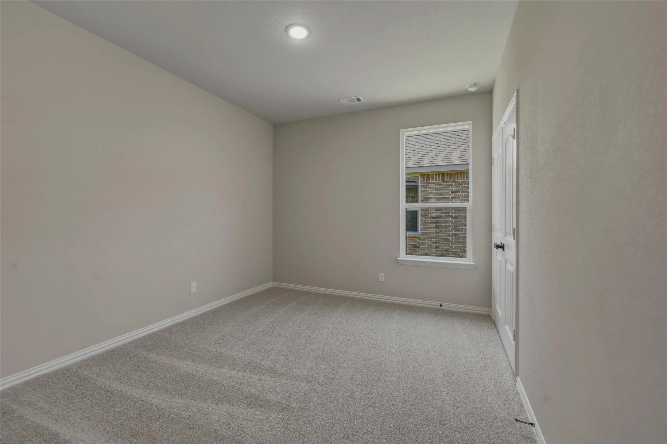 Carpeted room featuring a single window with white trim, a recessed ceiling light, and light gray wall paint
