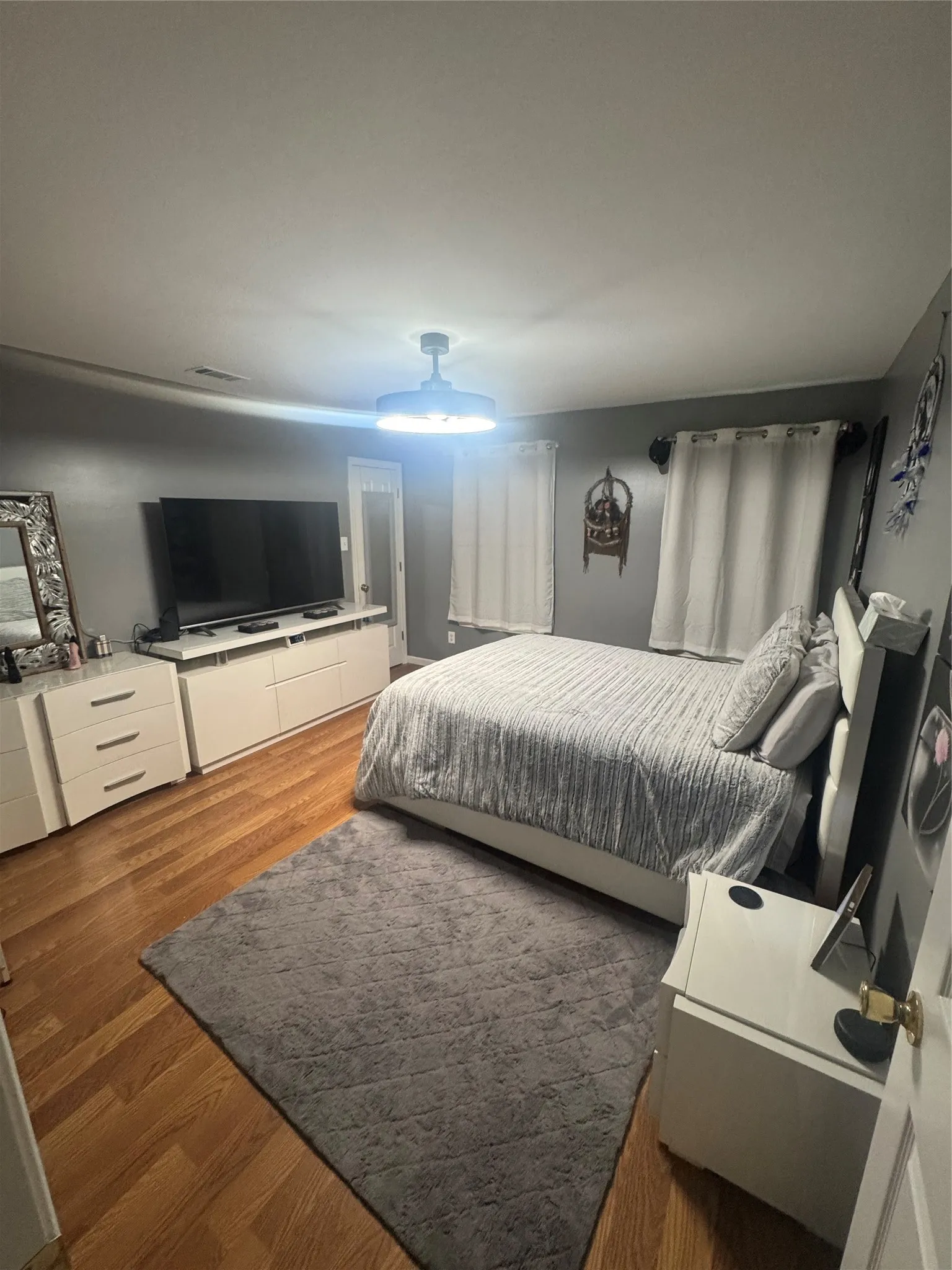 Wood-finish flooring throughout, complemented by a contemporary ceiling light fixture