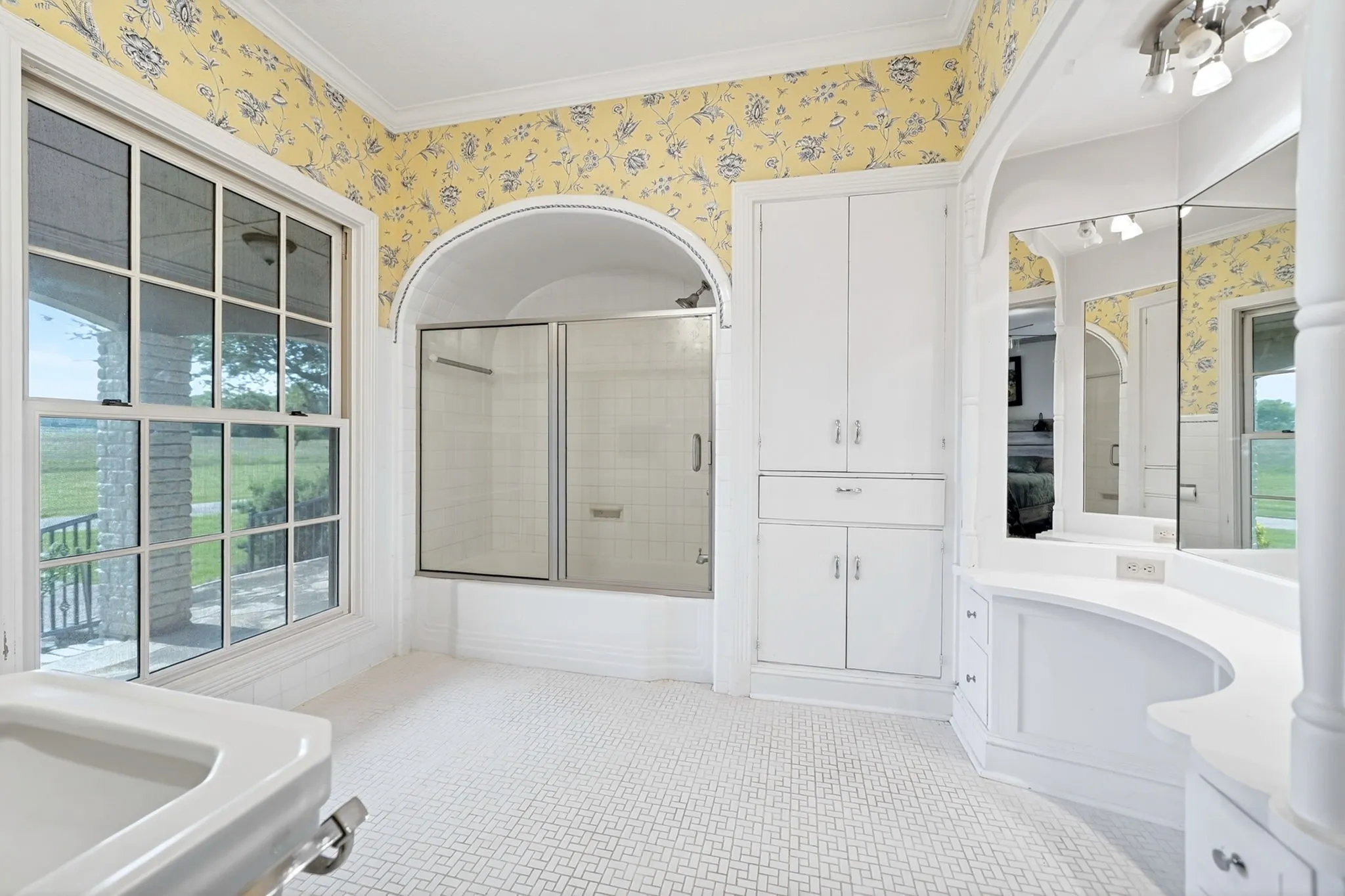 Bathroom featuring patterned wallpaper and patterned floor tile