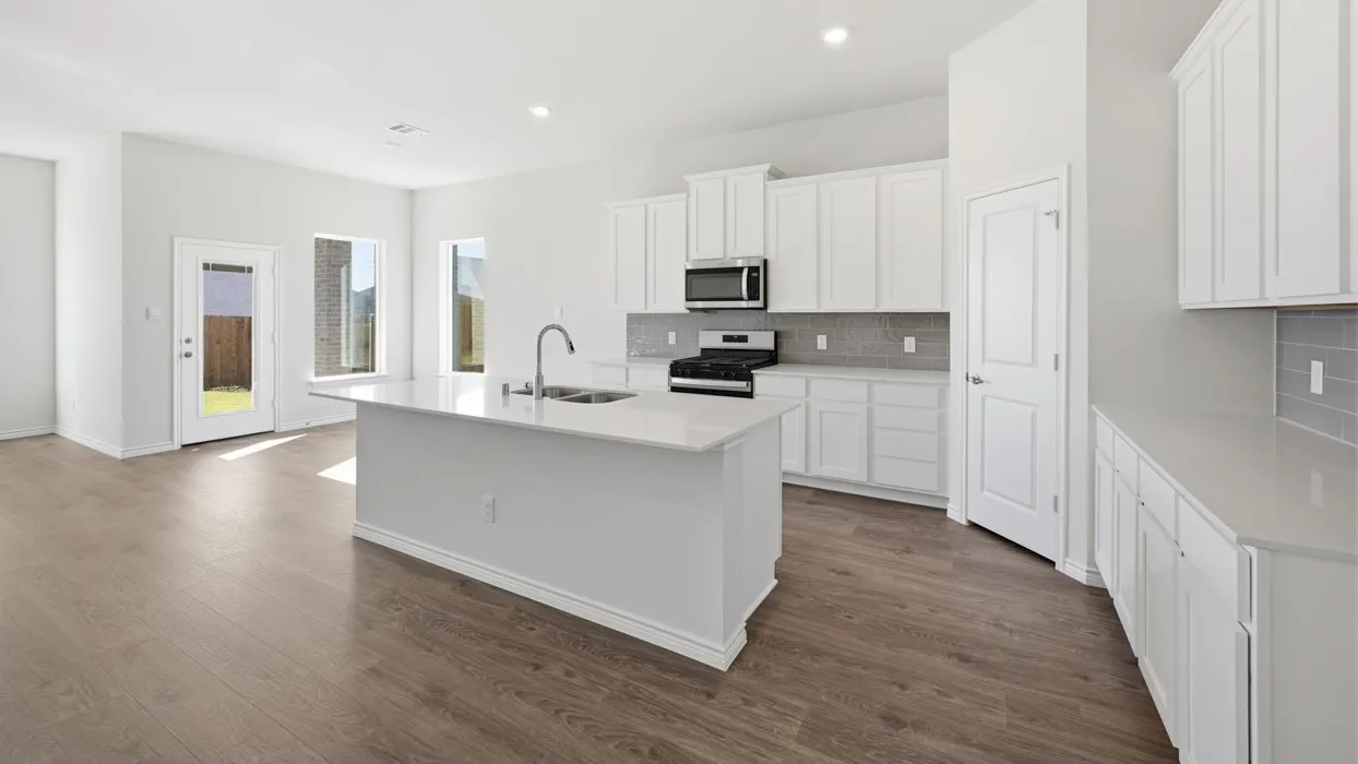 Contemporary kitchen featuring an island with an undermount sink, white cabinetry, integrated stainless steel appliances, a tiled backsplash, and wood-finish flooring