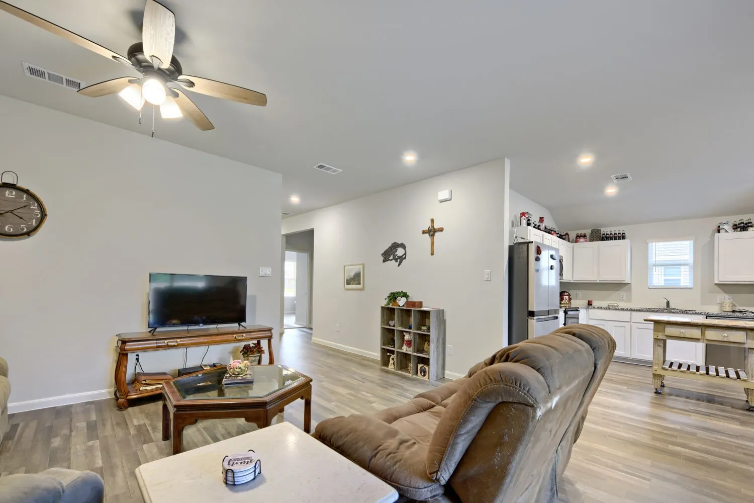 Open-concept living space featuring wood-finish flooring, recessed lighting, and a ceiling fan