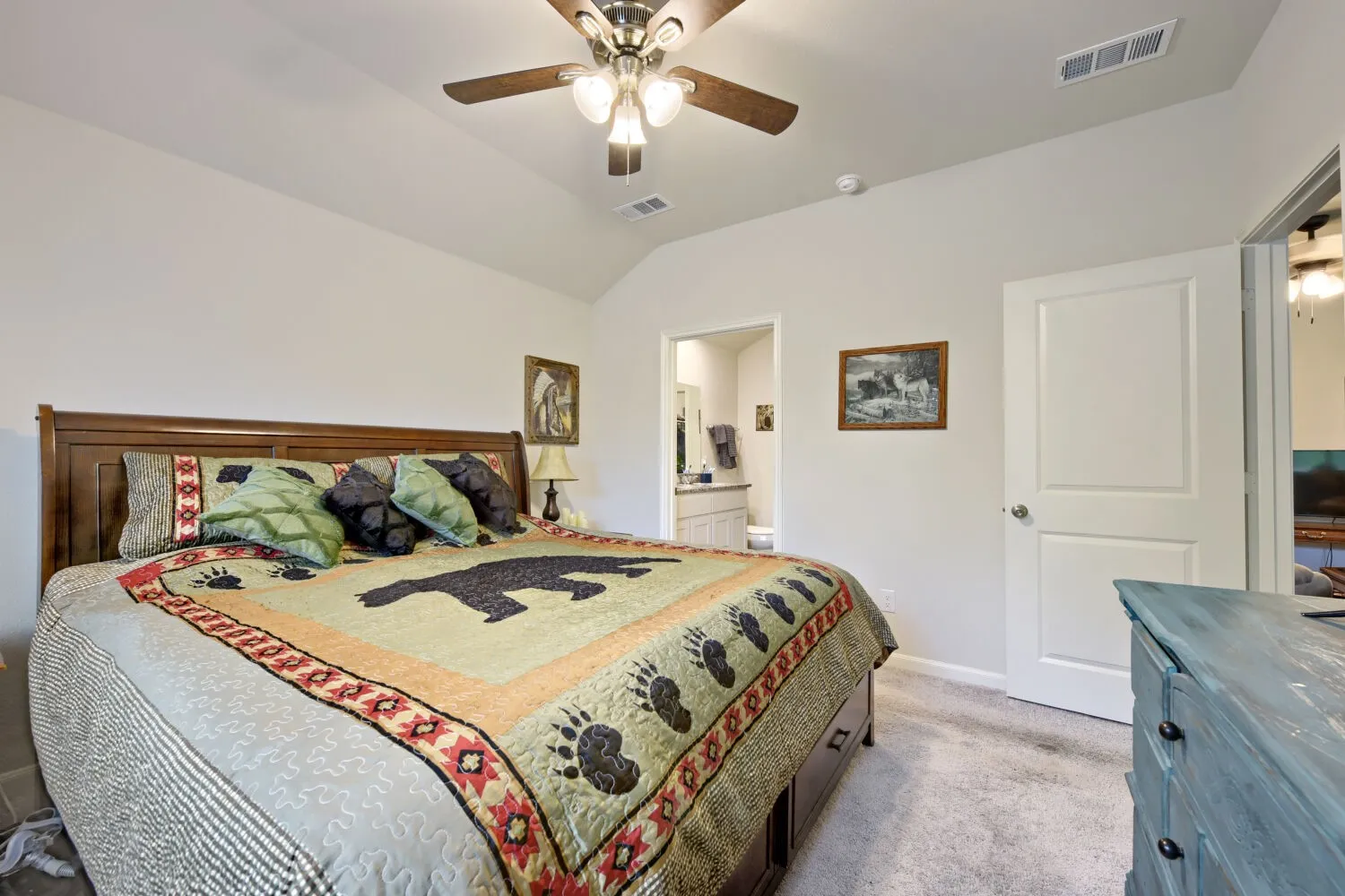 Carpeted bedroom featuring a vaulted ceiling and a ceiling fan with integrated lighting