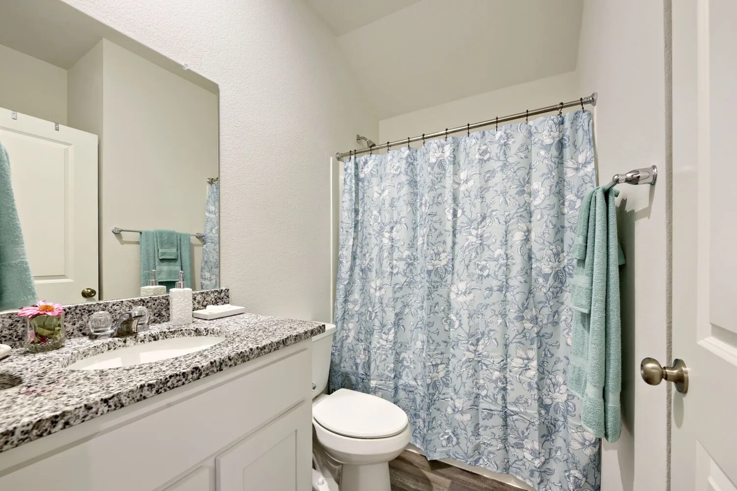 Bathroom featuring a vanity with a light-colored speckled countertop, a rectangular undermount sink, and chrome fixtures