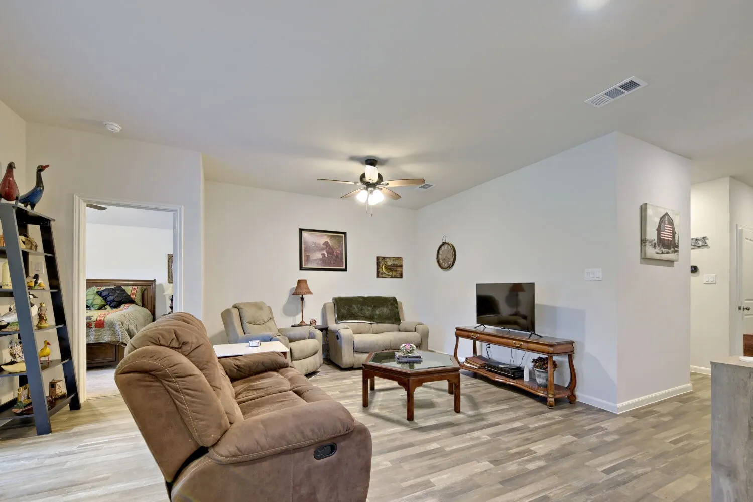 Open concept living area featuring wood-finish flooring and a ceiling fan with integrated lighting