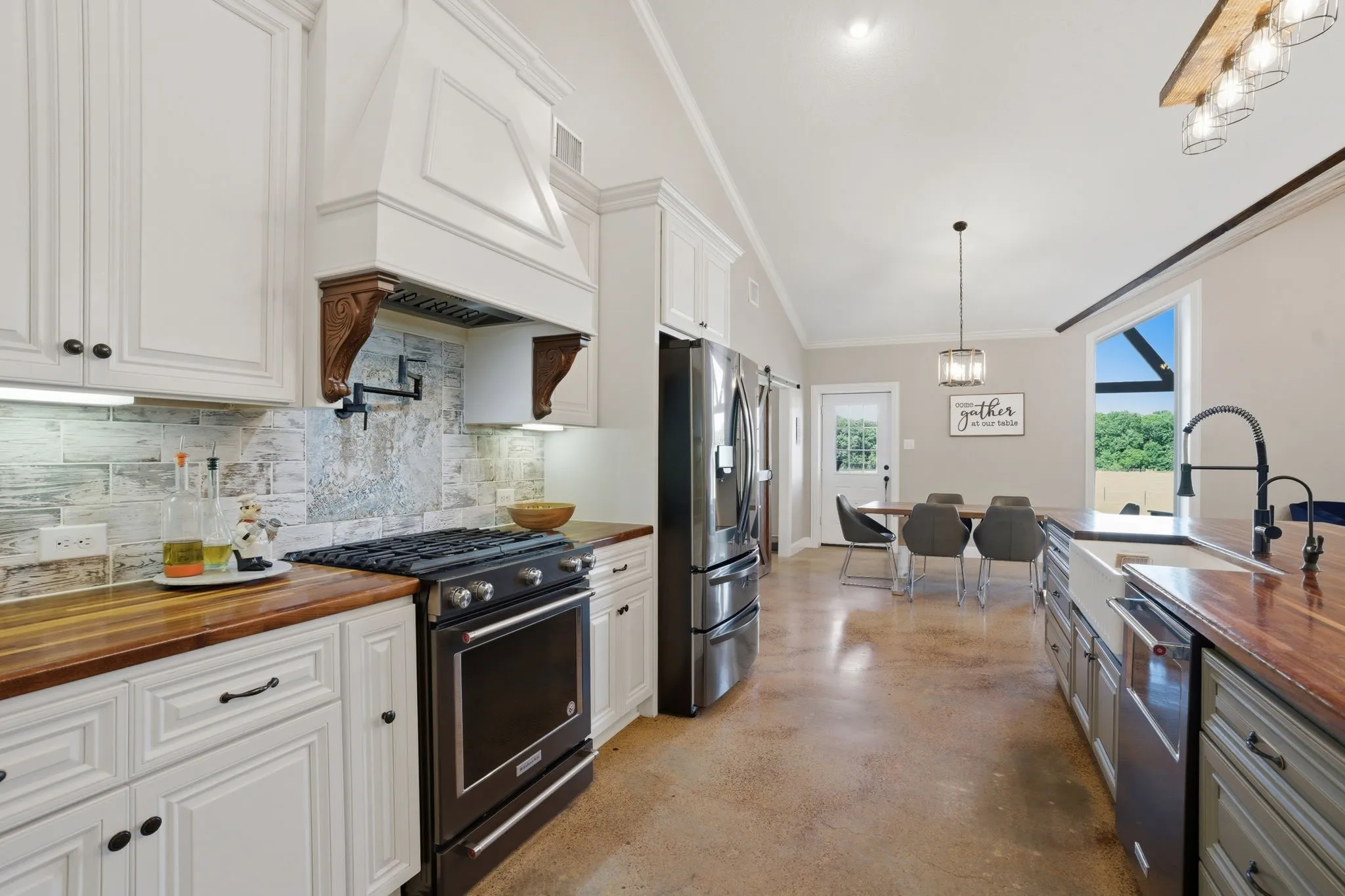 Gas range with pot filler and custom range hood.  Kitchen Aid appliances.