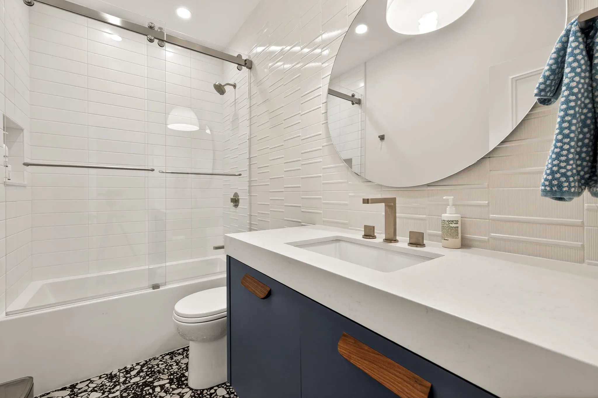Bathroom featuring a dark vanity with wood-finish hardware, a white countertop, and a vessel sink with a brushed nickel faucet