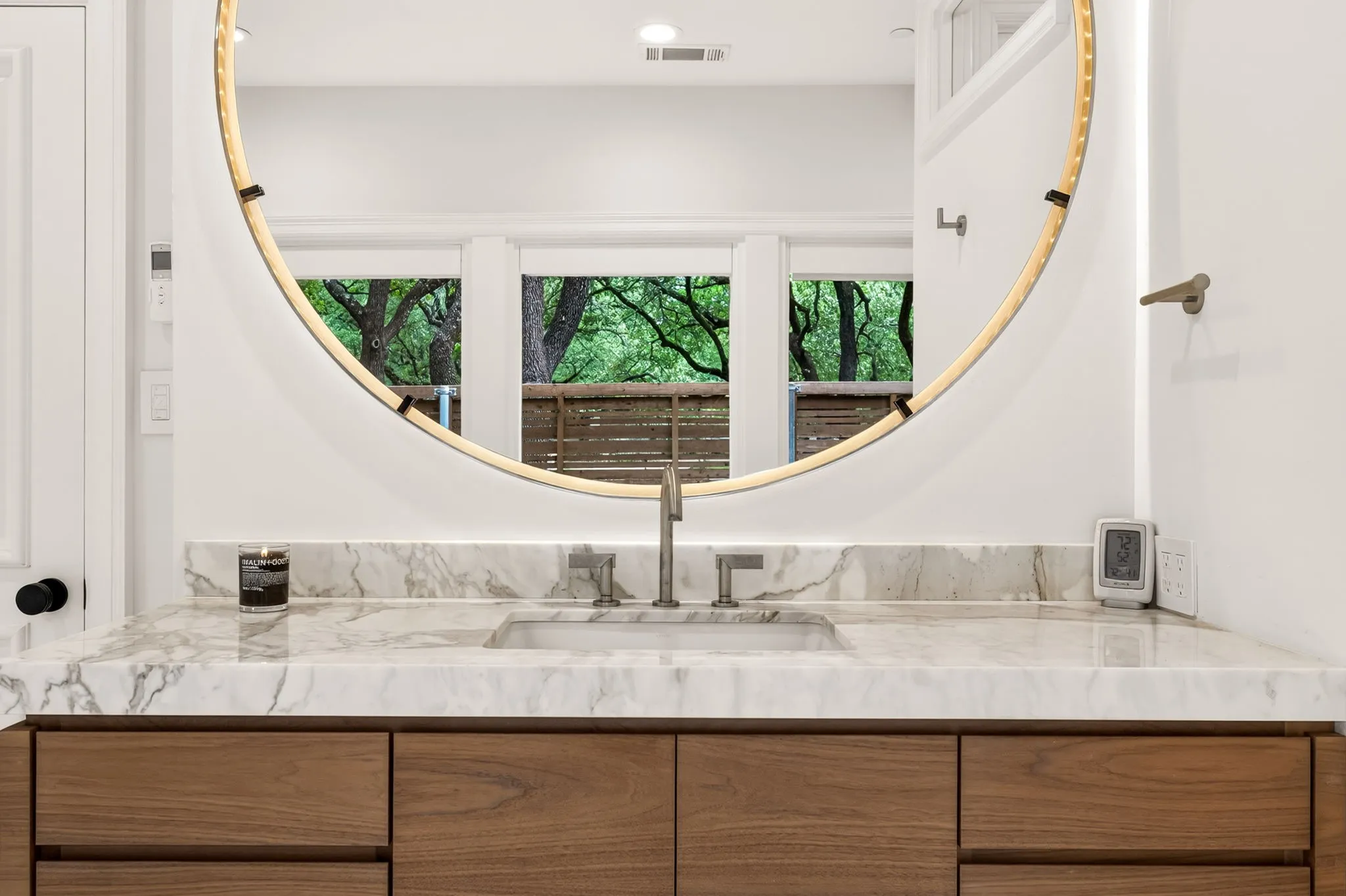 Vanity featuring a wood-finish cabinet with multiple drawers, a stone countertop with an integrated sink, and a wall-mounted faucet