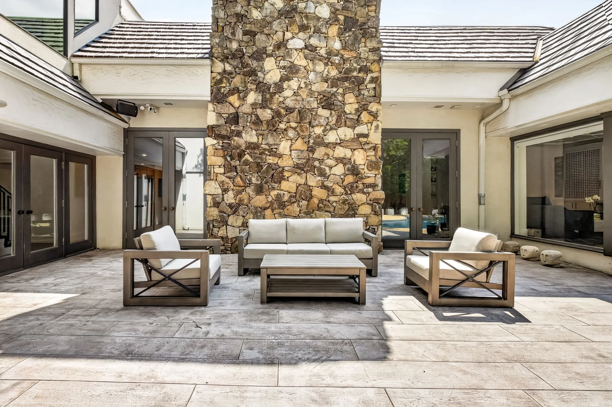 Expansive stone patio featuring a prominent natural stone chimney facade