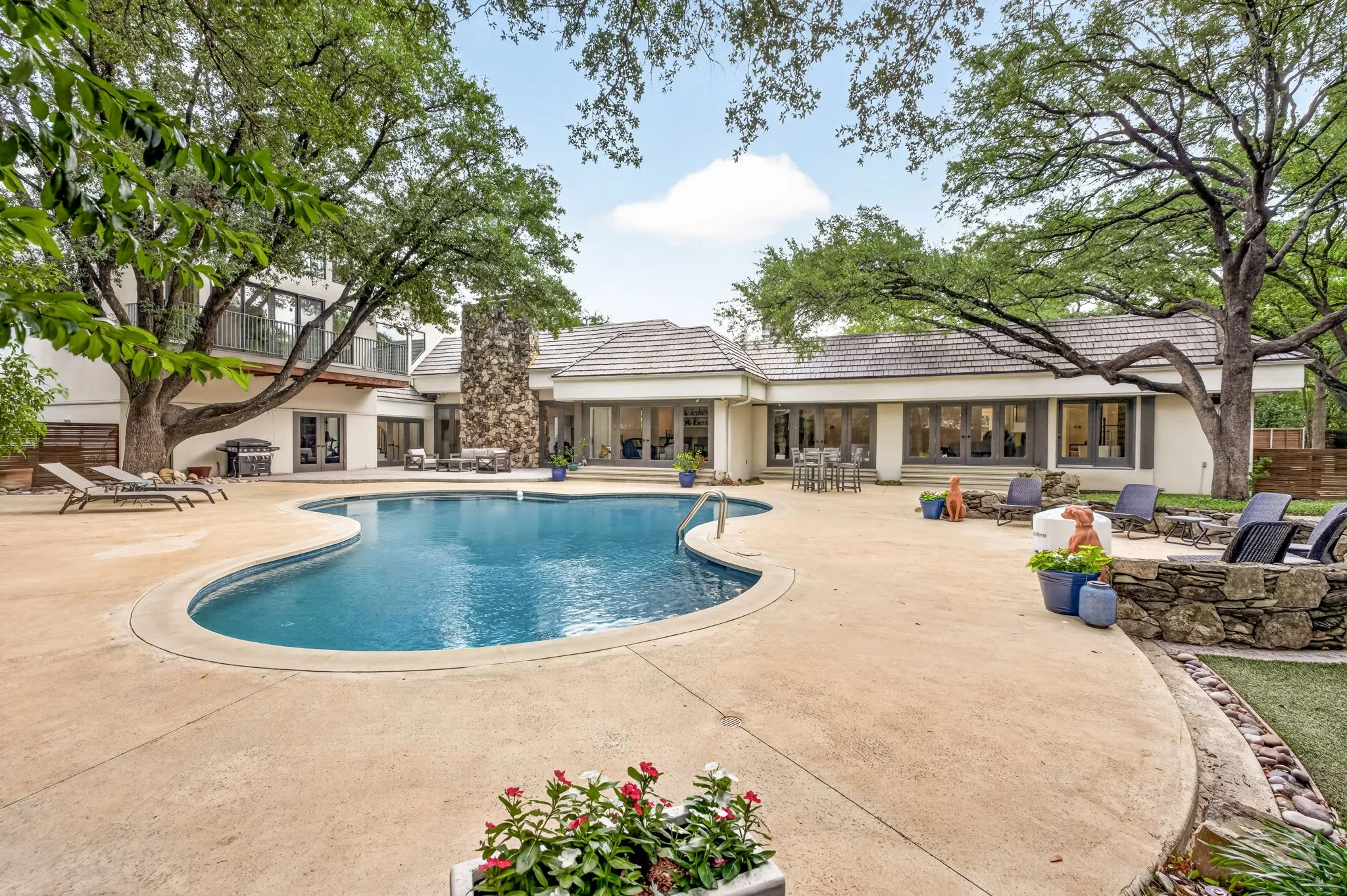 Expansive freeform swimming pool surrounded by a large concrete patio