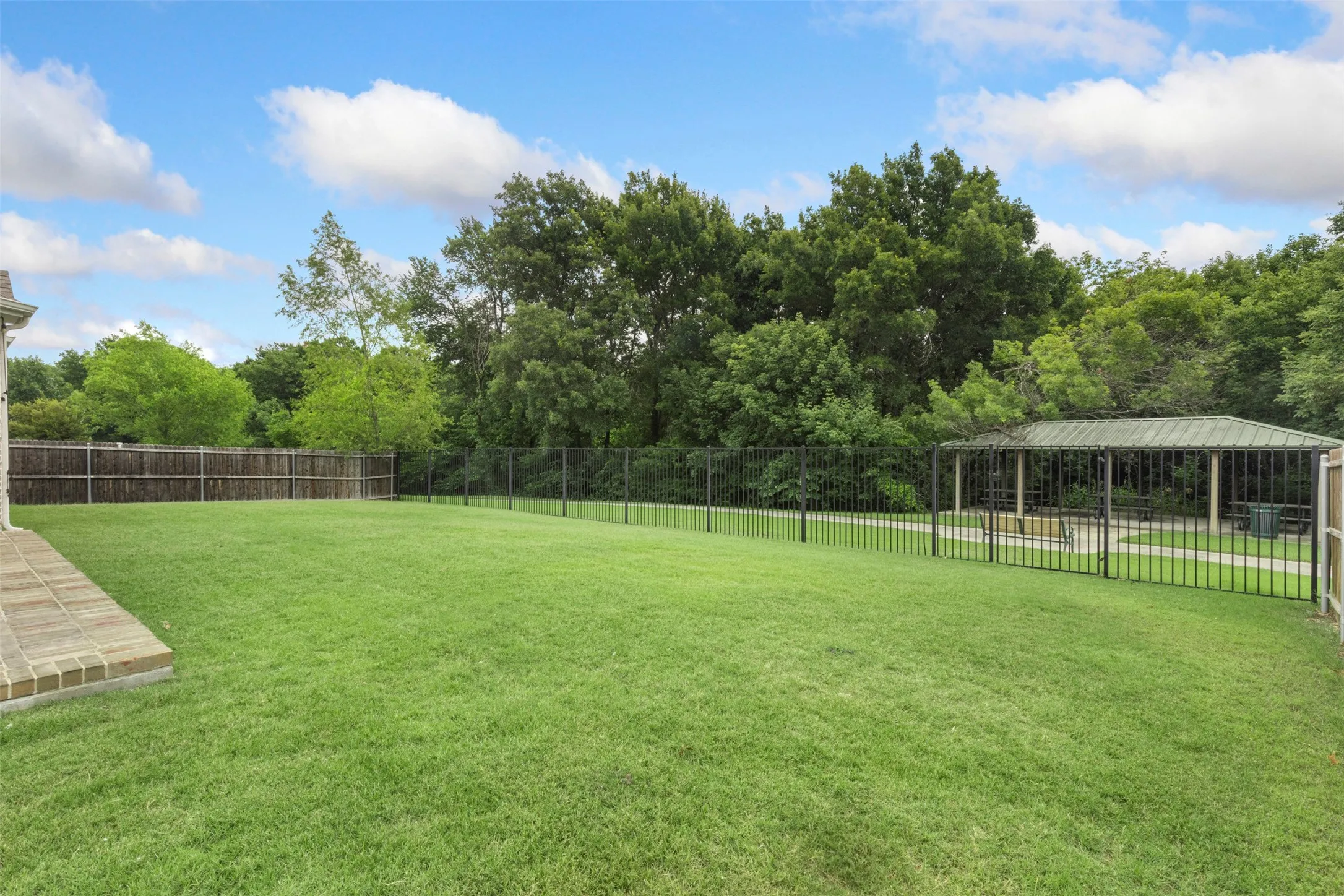 Large backyard with walking trails and park past fence