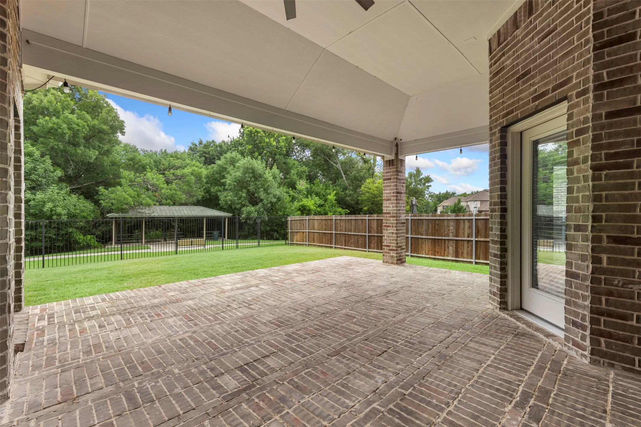Large covered patio over looking backyard and park behind house