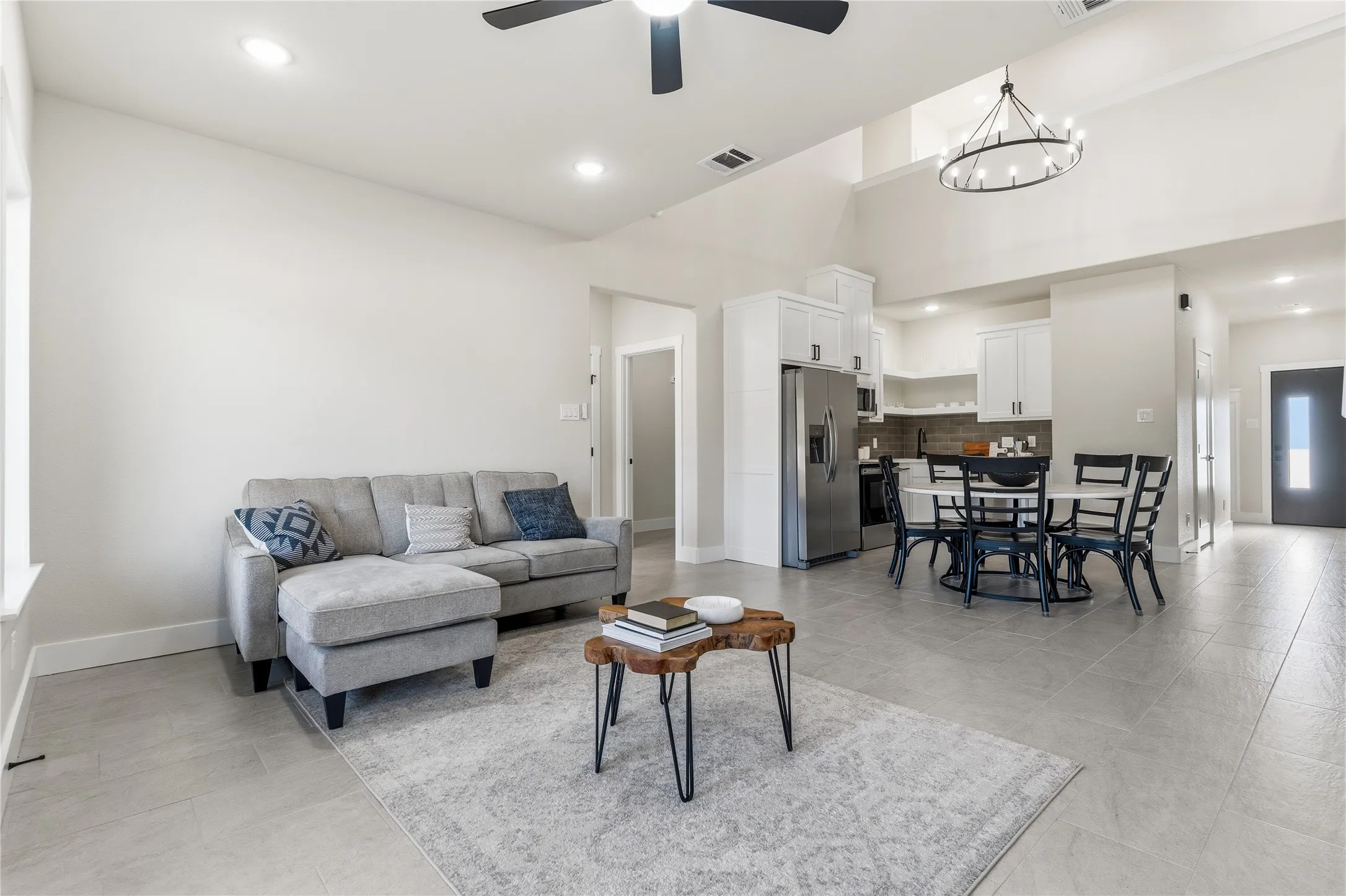Open-concept living space featuring high ceilings, recessed lighting, tile flooring, and a contemporary ceiling fan