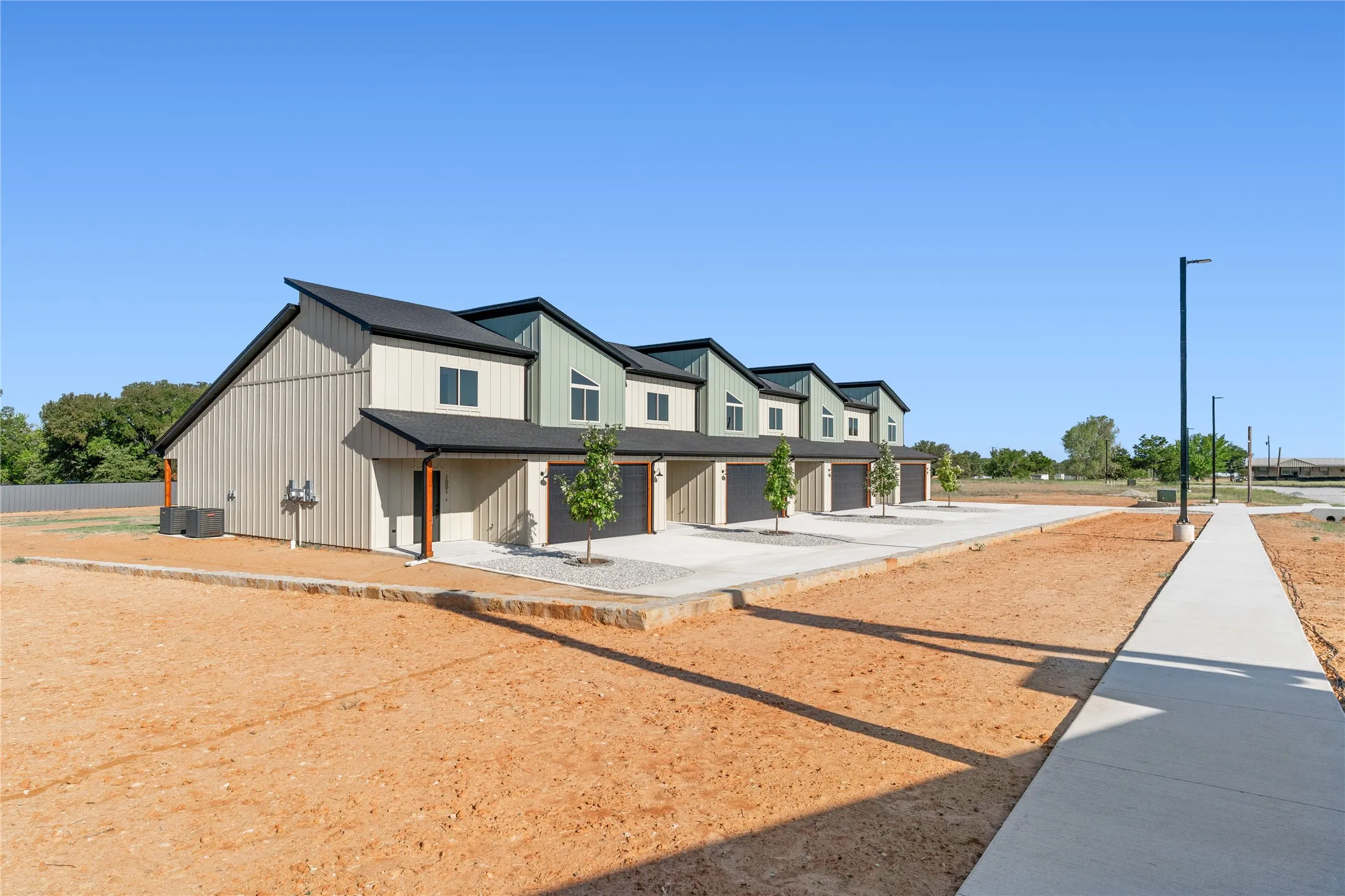 Contemporary exterior with multi-toned vertical siding, black-framed windows, and sloped dark roofing