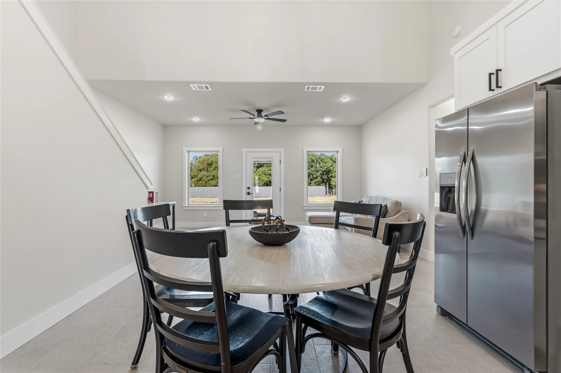 Open-concept living area with vaulted ceilings, recessed lighting, and tile flooring