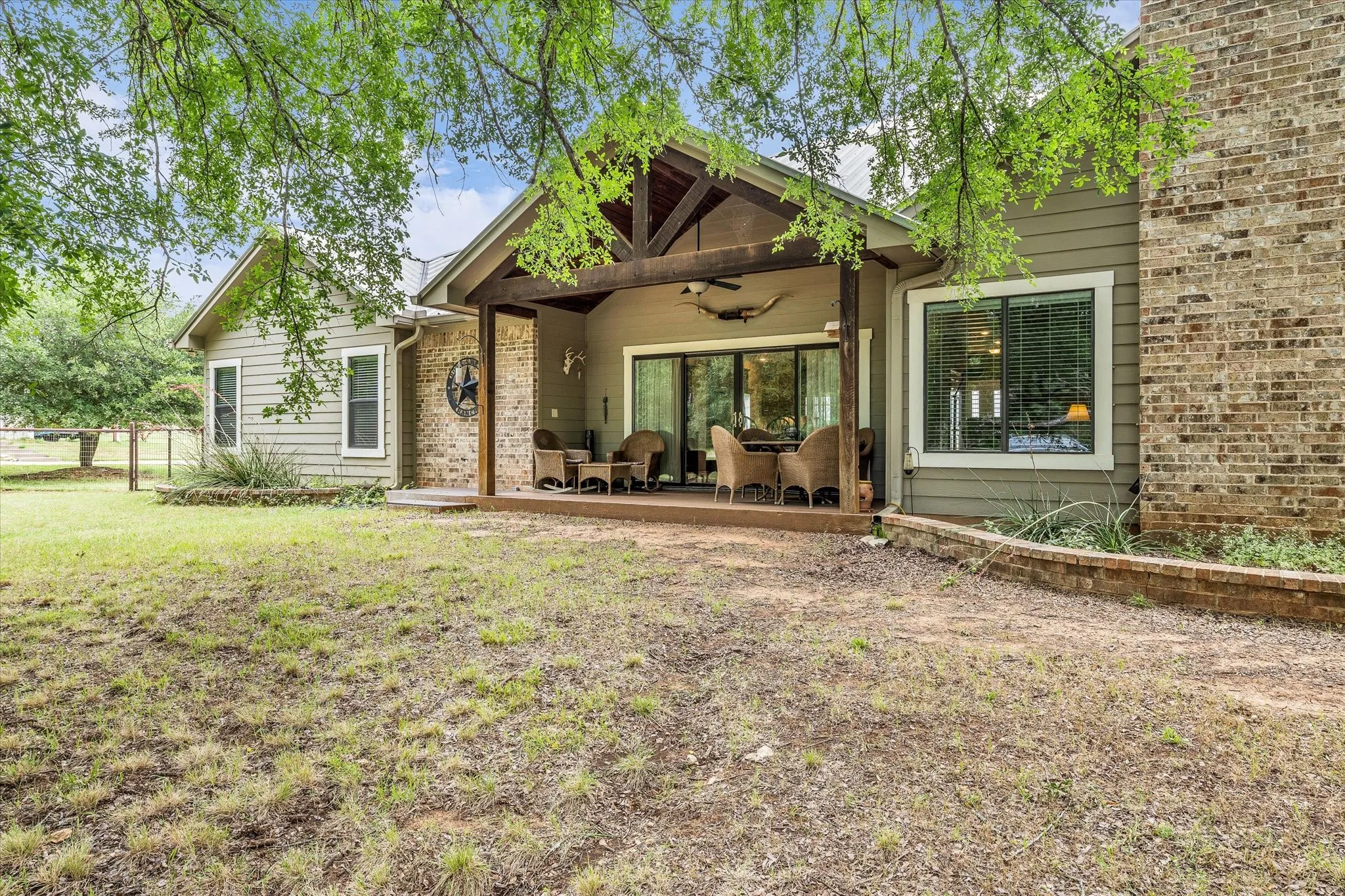 Expansive covered patio featuring exposed timber beams, recessed lighting, and a ceiling fan