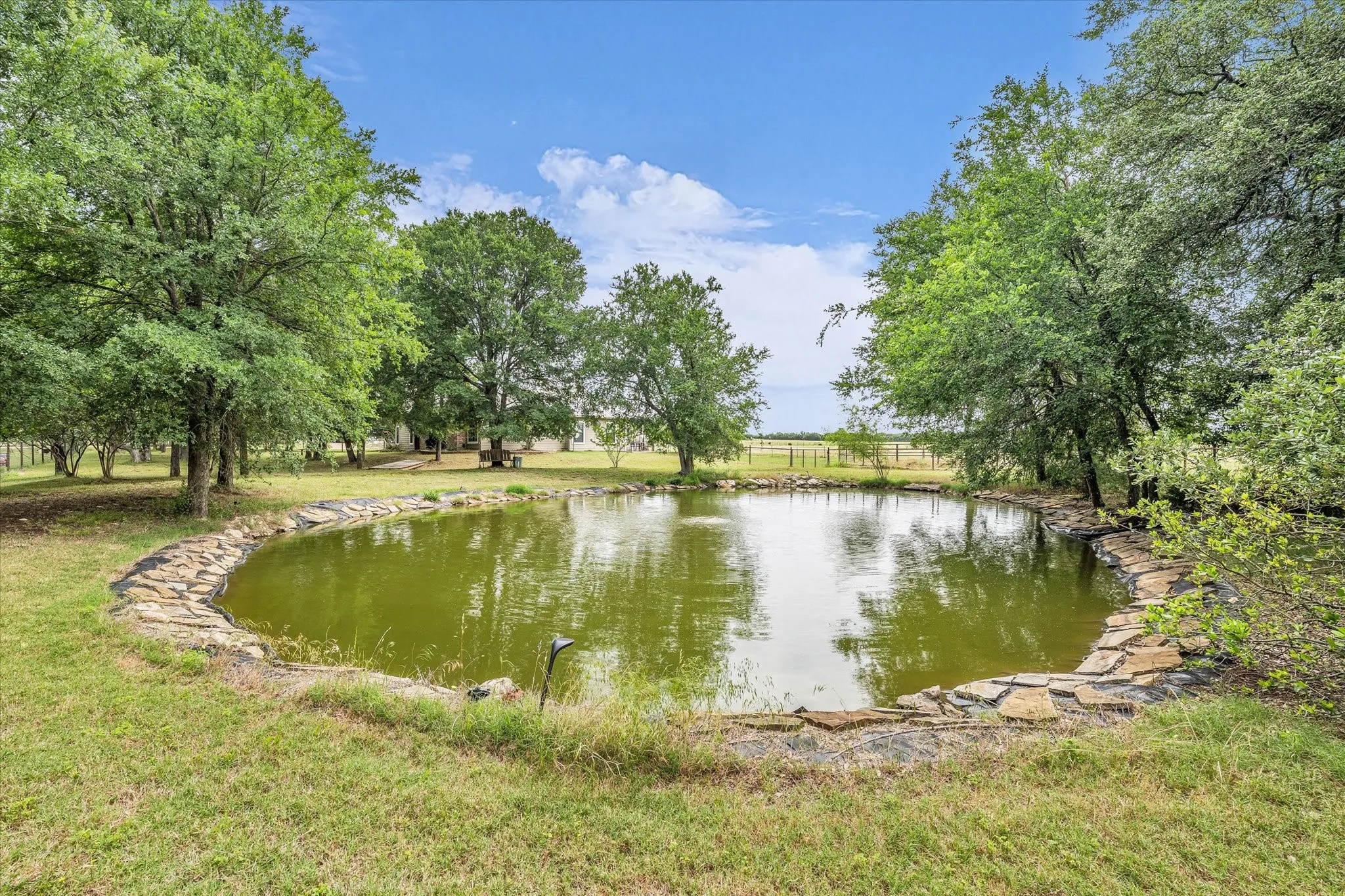 Pond with a natural stone border and surrounding trees