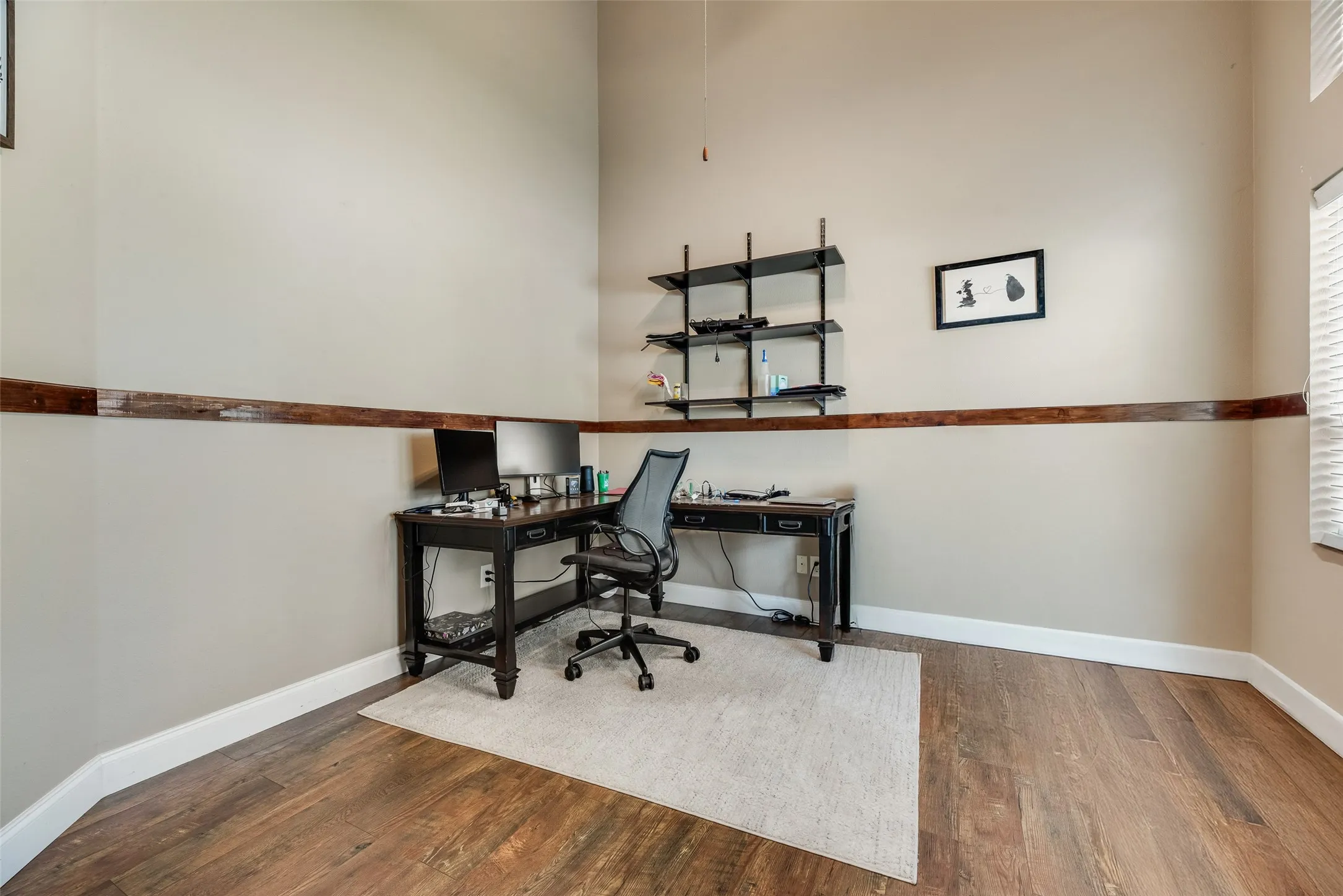 Room featuring wood-finish flooring, a decorative wood-tone wall accent, and neutral wall tones