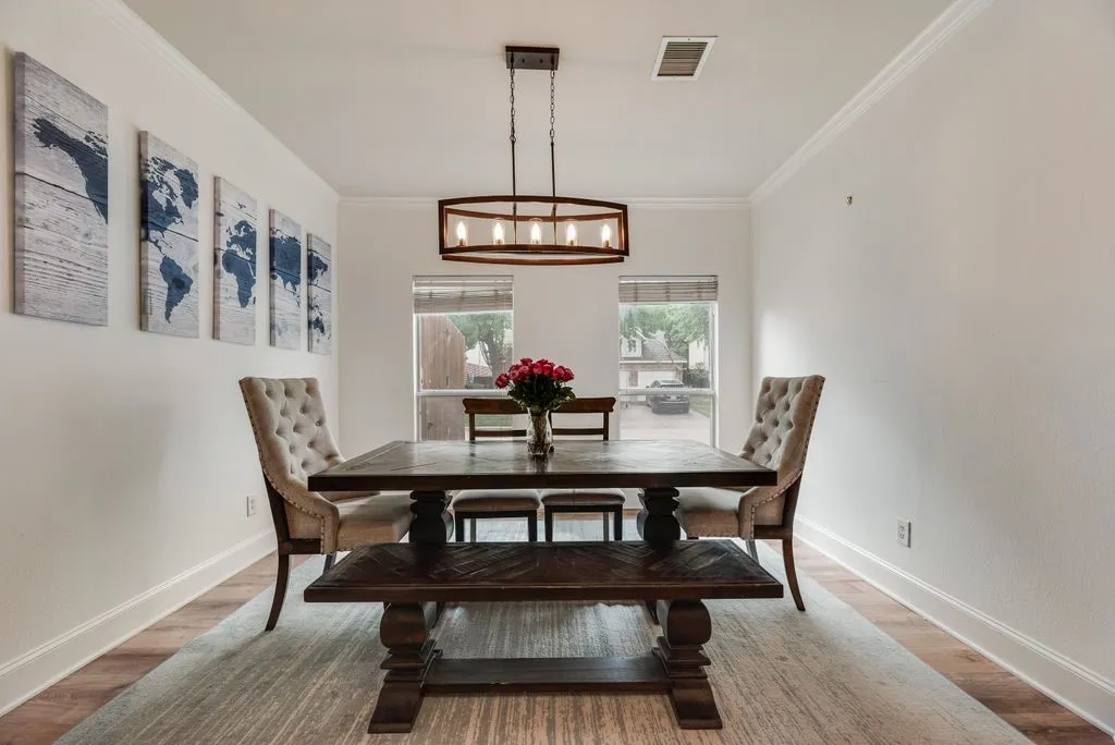 Dining area featuring wood-finish flooring, white baseboards, and white crown molding