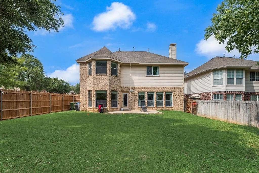 Expansive green lawn with a privacy fence