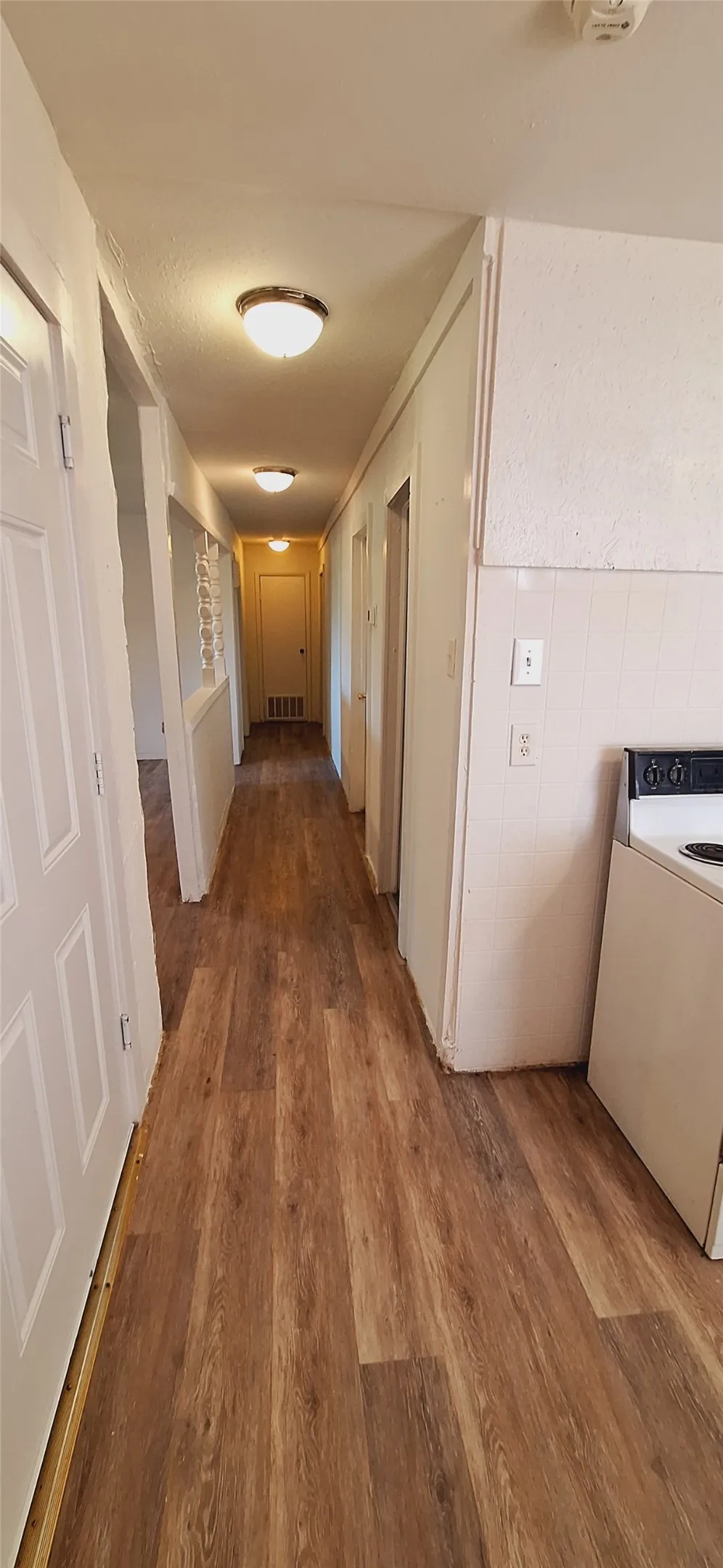 Hallway featuring wood-finish flooring and flush-mount ceiling lighting