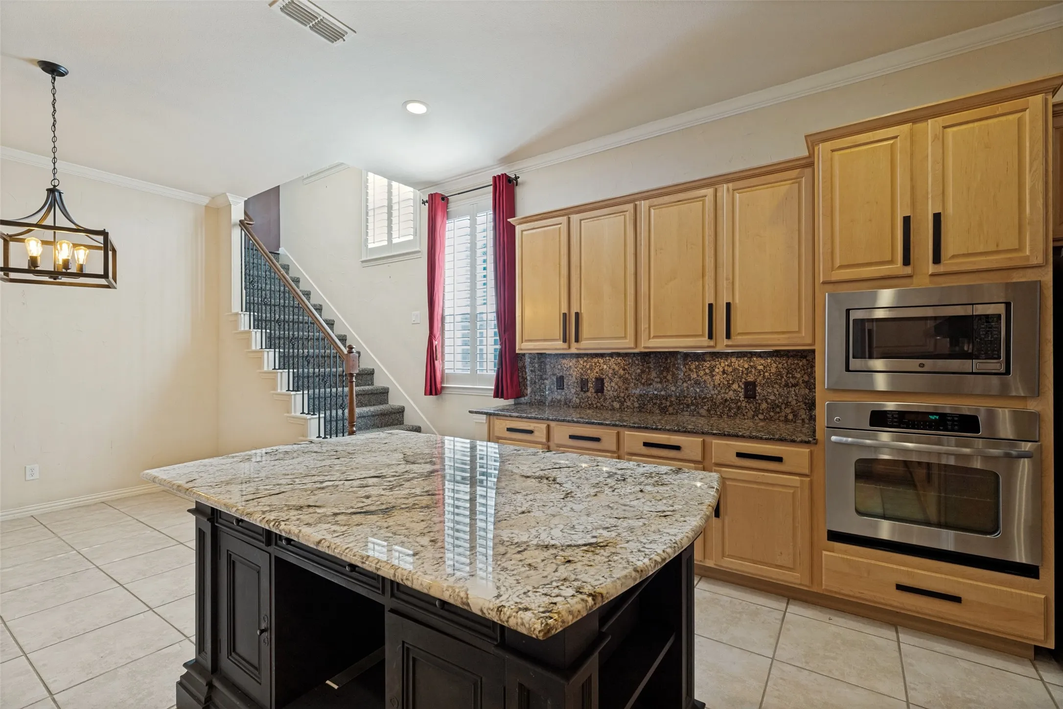 Kitchen island with a light-toned granite countertop and dark wood-finish cabinetry