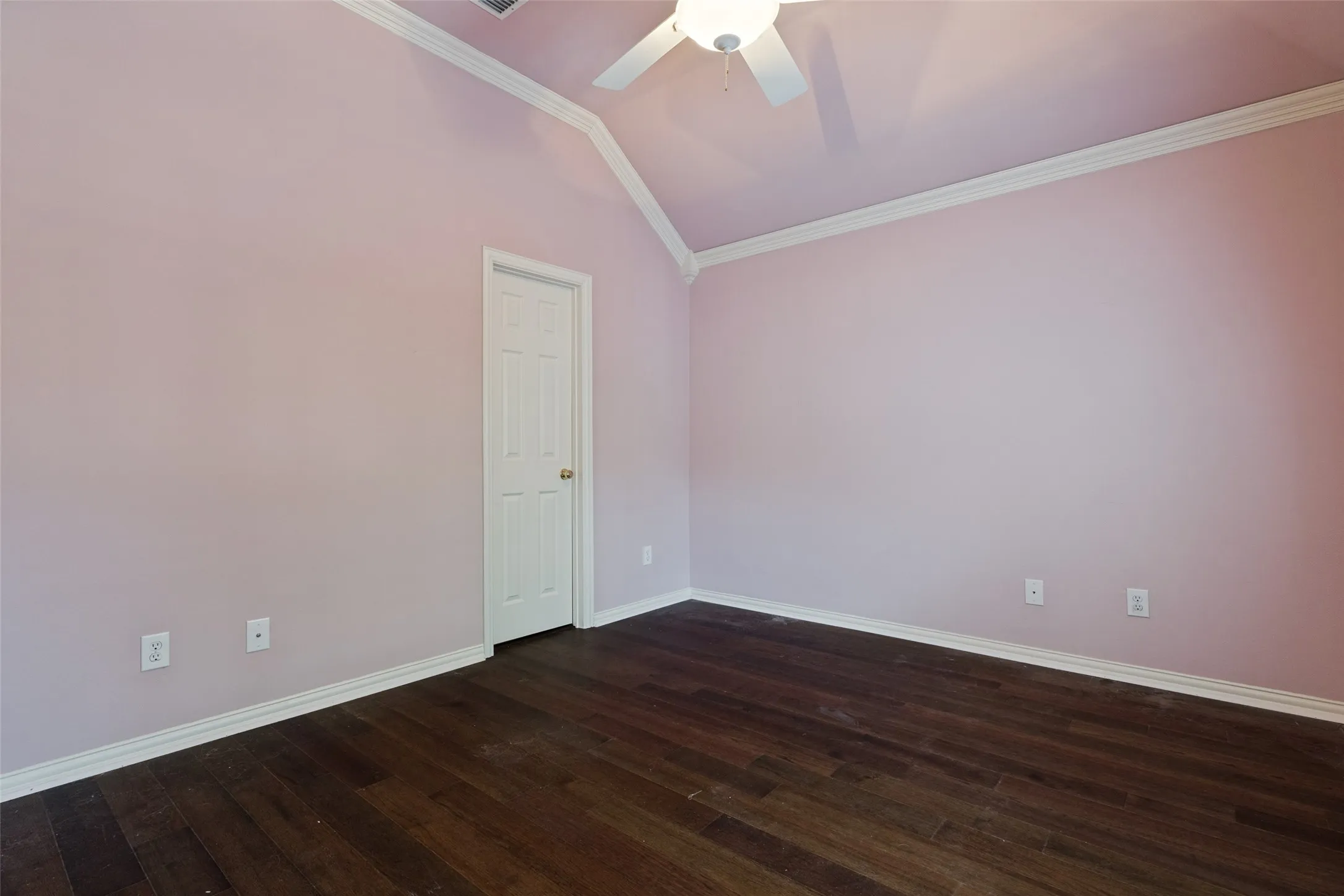 Room featuring a vaulted ceiling with a ceiling fan, wood-finish flooring, white crown molding, and white baseboards