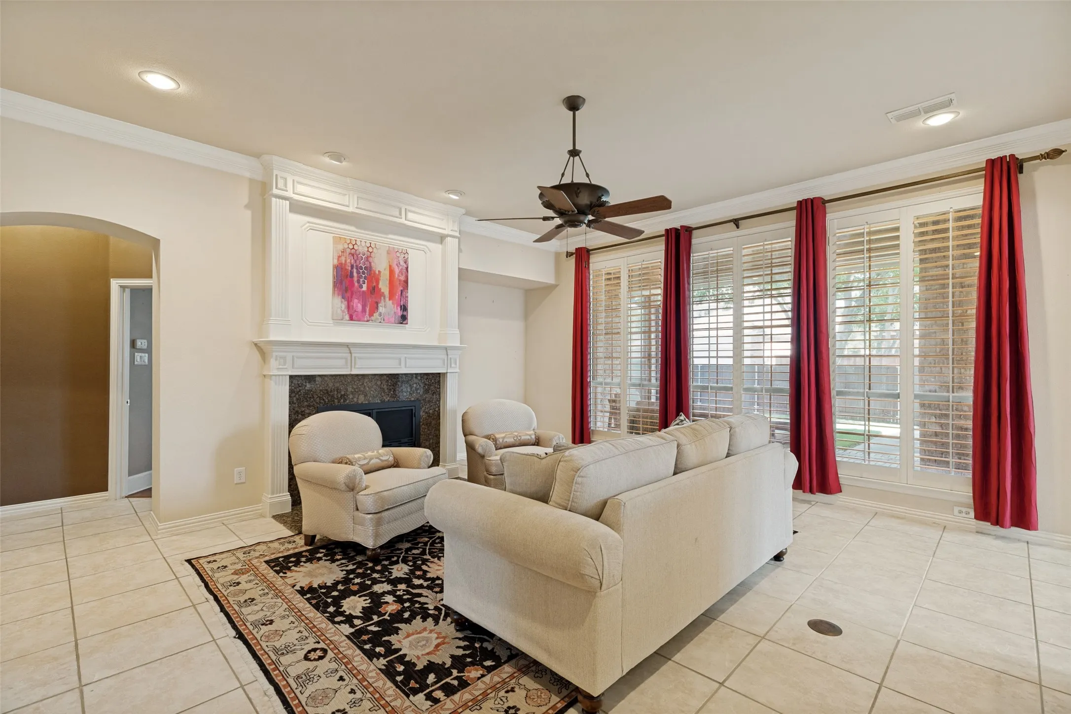 Living space featuring a prominent fireplace with a detailed mantel, dark stone surround, and hearth