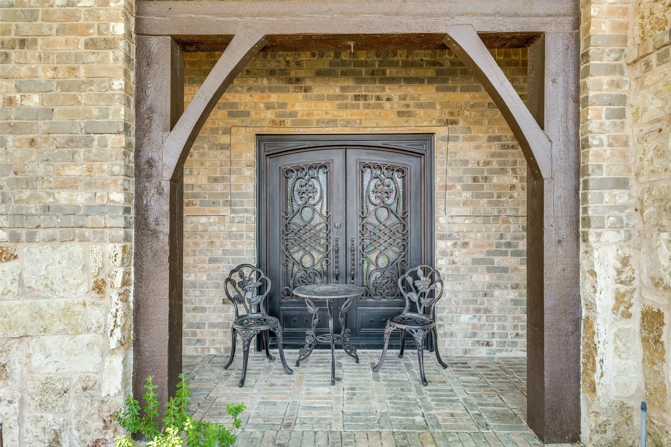 Entryway featuring a double door with ornate wrought iron detailing and glass inserts