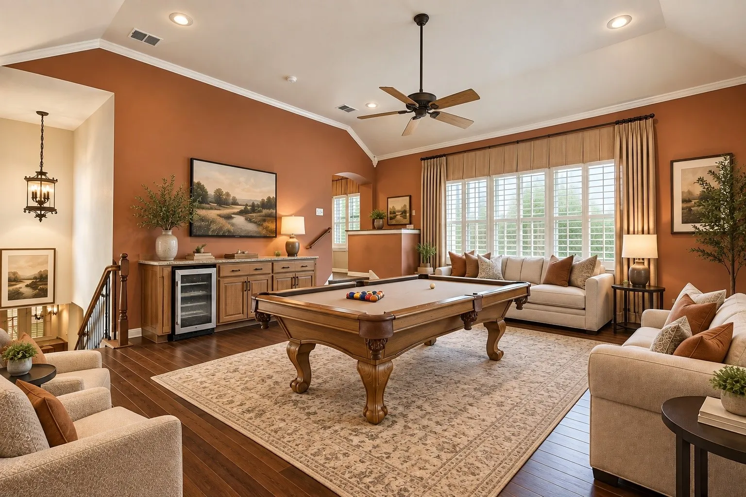 Spacious room featuring vaulted ceilings, wood-finish flooring, a built-in wet bar with beverage cooler, a ceiling fan, and large windows with plantation shutters