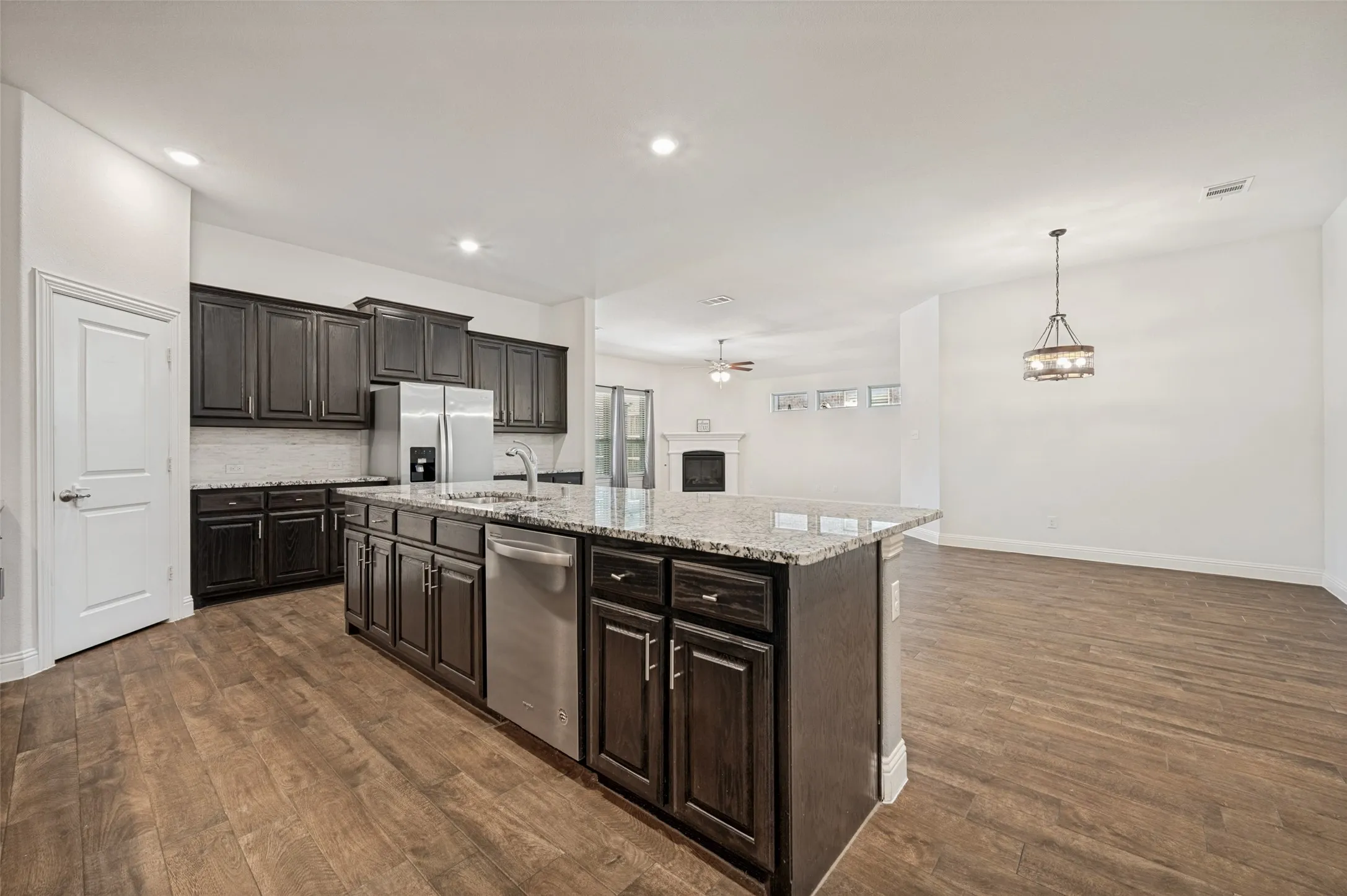 Kitchen island featuring a granite countertop, dark wood-finish cabinetry, and stainless steel​​‌​​​​‌​​‌‌​‌‌​​​‌‌​‌​‌​‌​​​‌​​ appliances