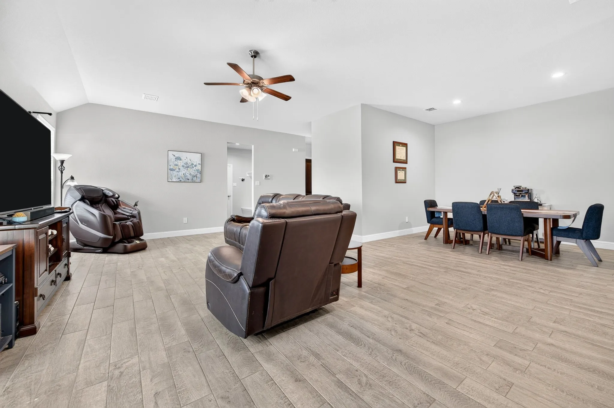 Spacious open-concept interior featuring light wood-finish flooring throughout