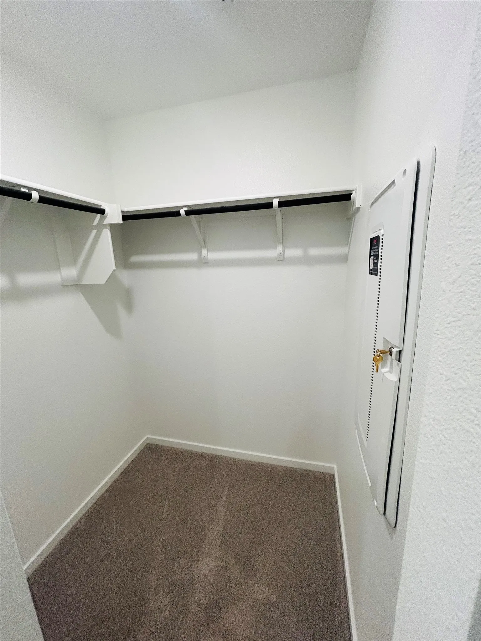 Built-in shelving with hanging rods and carpet flooring