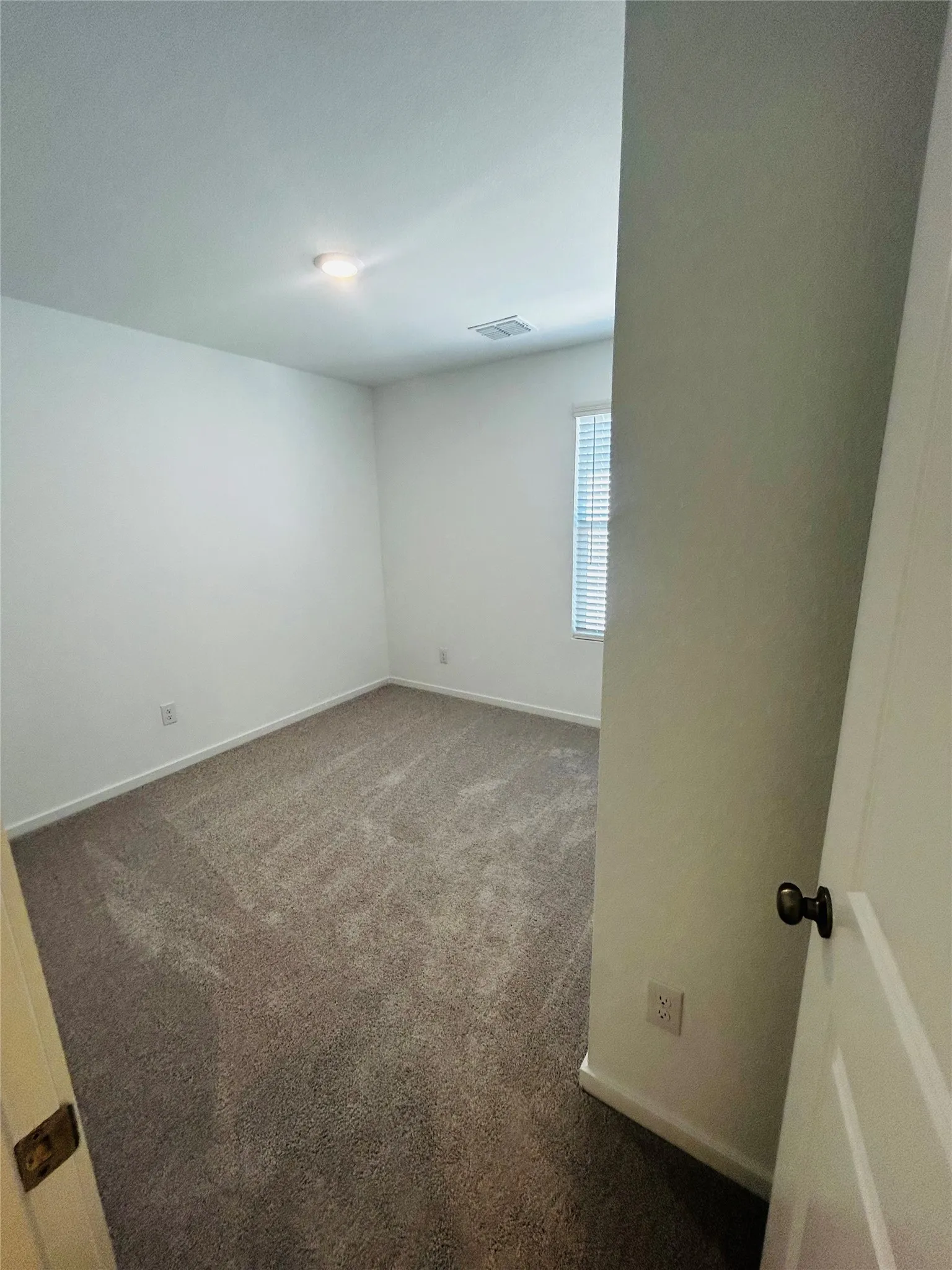 Neutral tone wall paint with a window featuring horizontal blinds