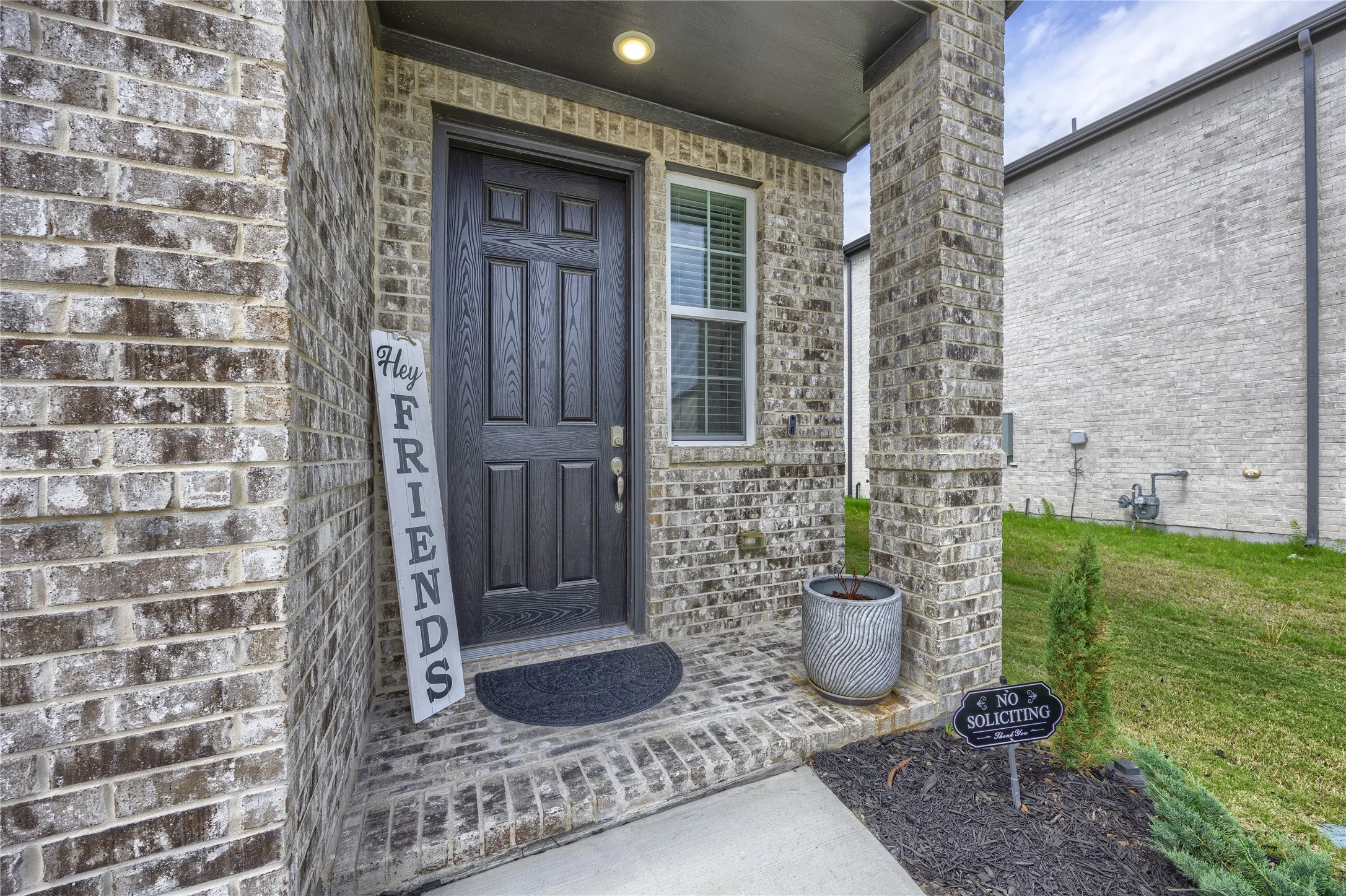 This inviting front entry features a charming, covered porch with brick pillars and a beautiful accent window that lets in natural light. The spacious entryway provides ample room for a welcoming front mat and decorative planters, creating excellent curb appeal.