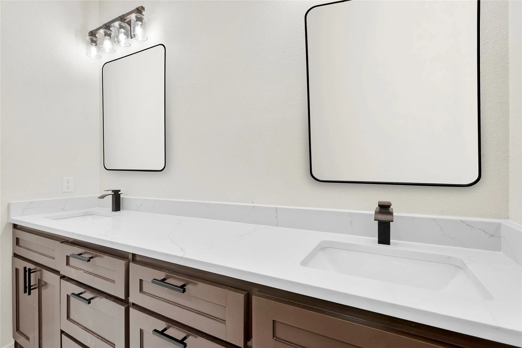 Double vanity with rich wood-finish cabinetry, white countertops, and integrated rectangular sinks