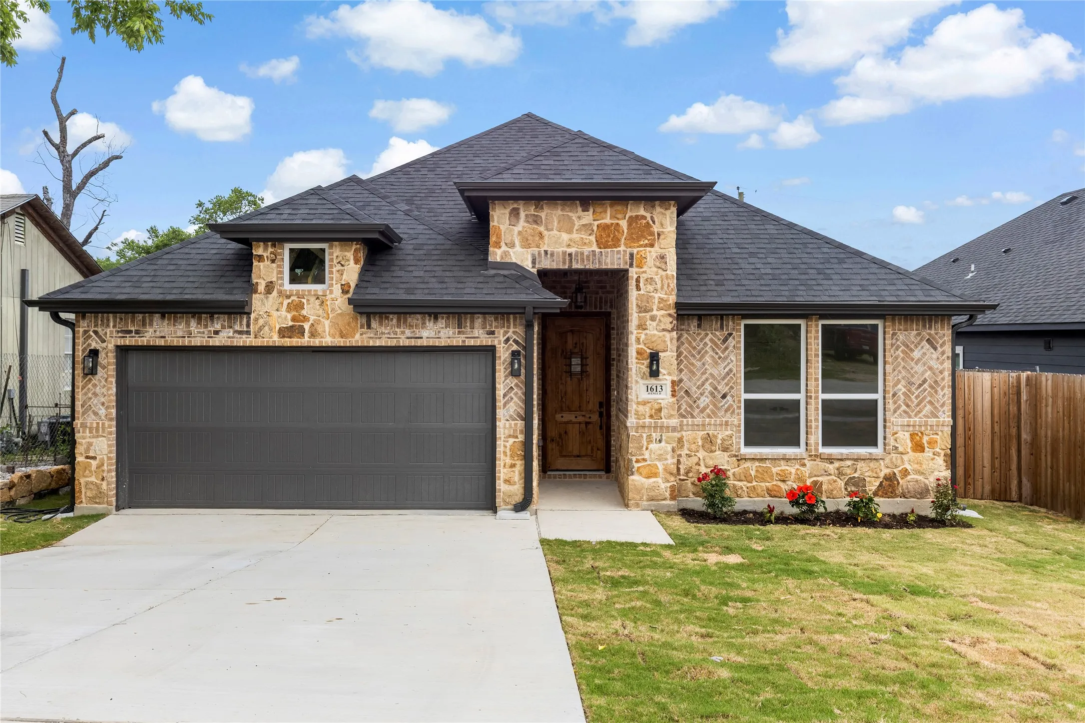 Stone and brick exterior with a dark asphalt shingle roof