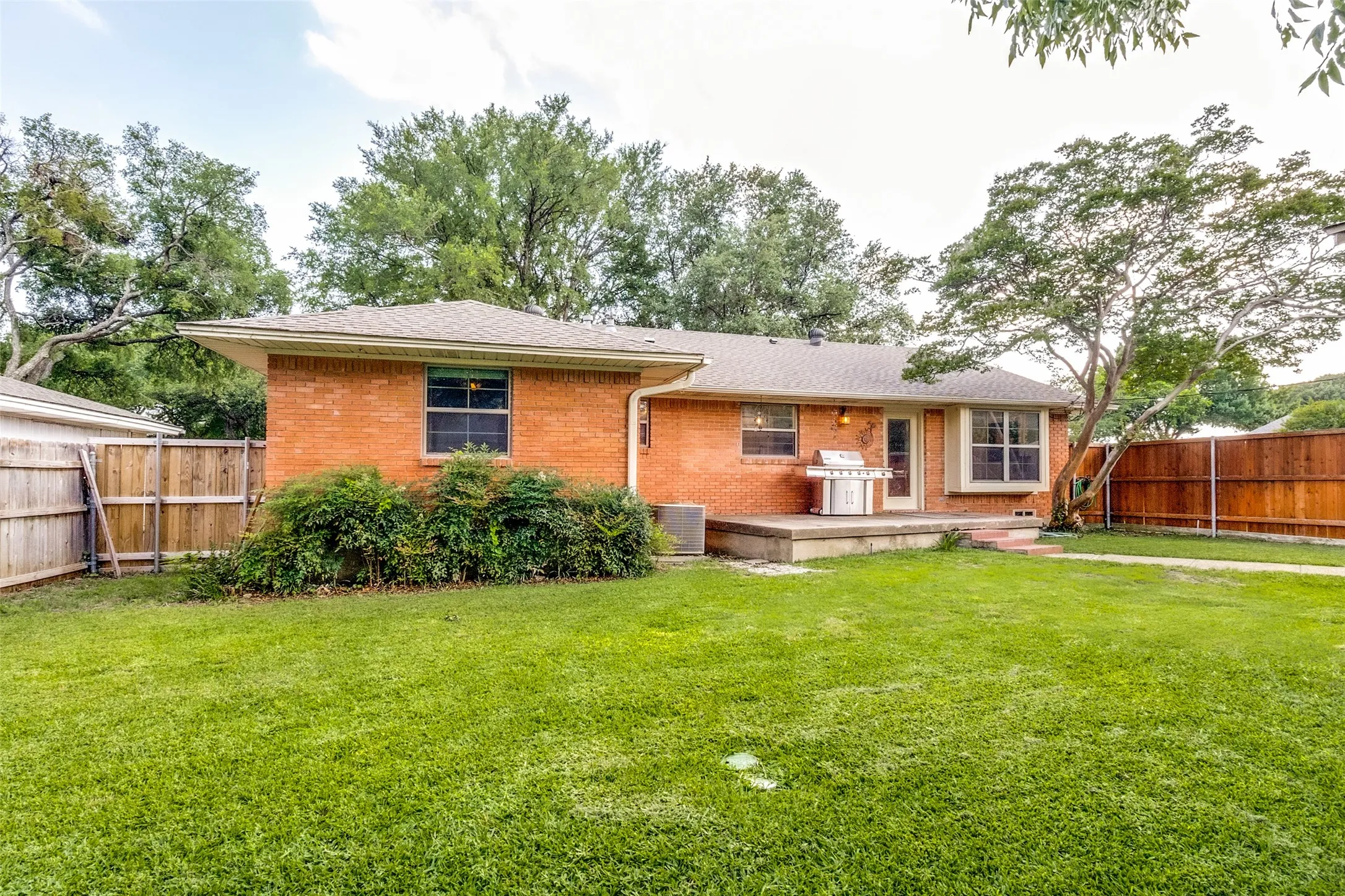 mature landscaping, and a spacious green lawn