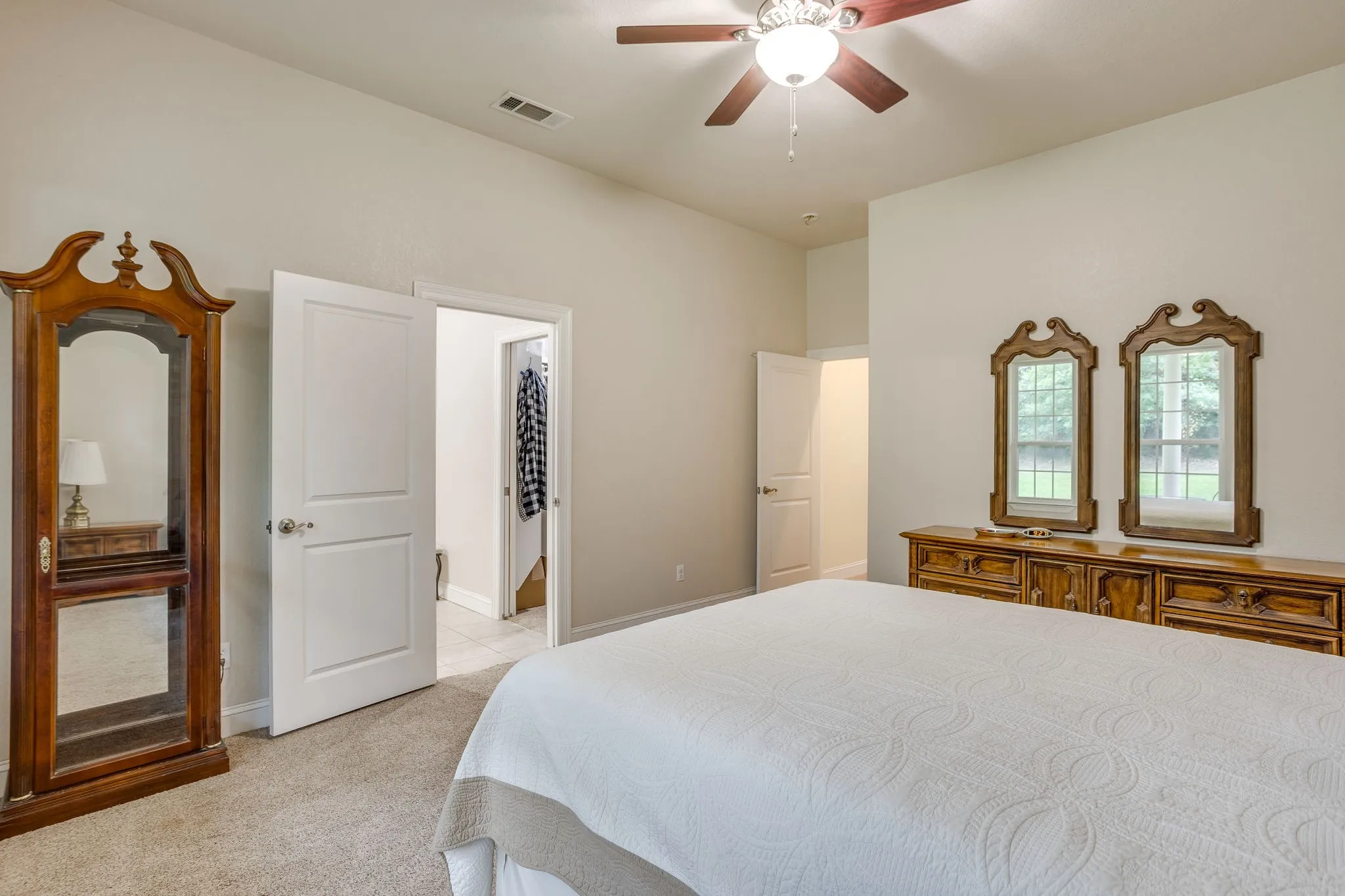 Carpeted room featuring a ceiling fan with integrated lighting, a vaulted ceiling, and white interior doors