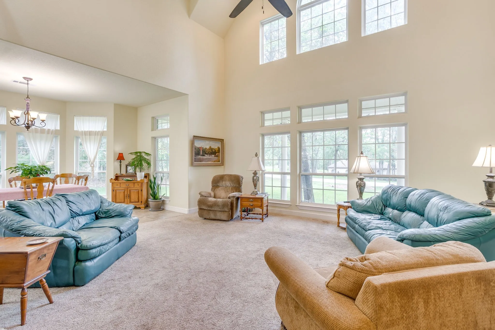 Expansive living area with a vaulted ceiling and a ceiling fan