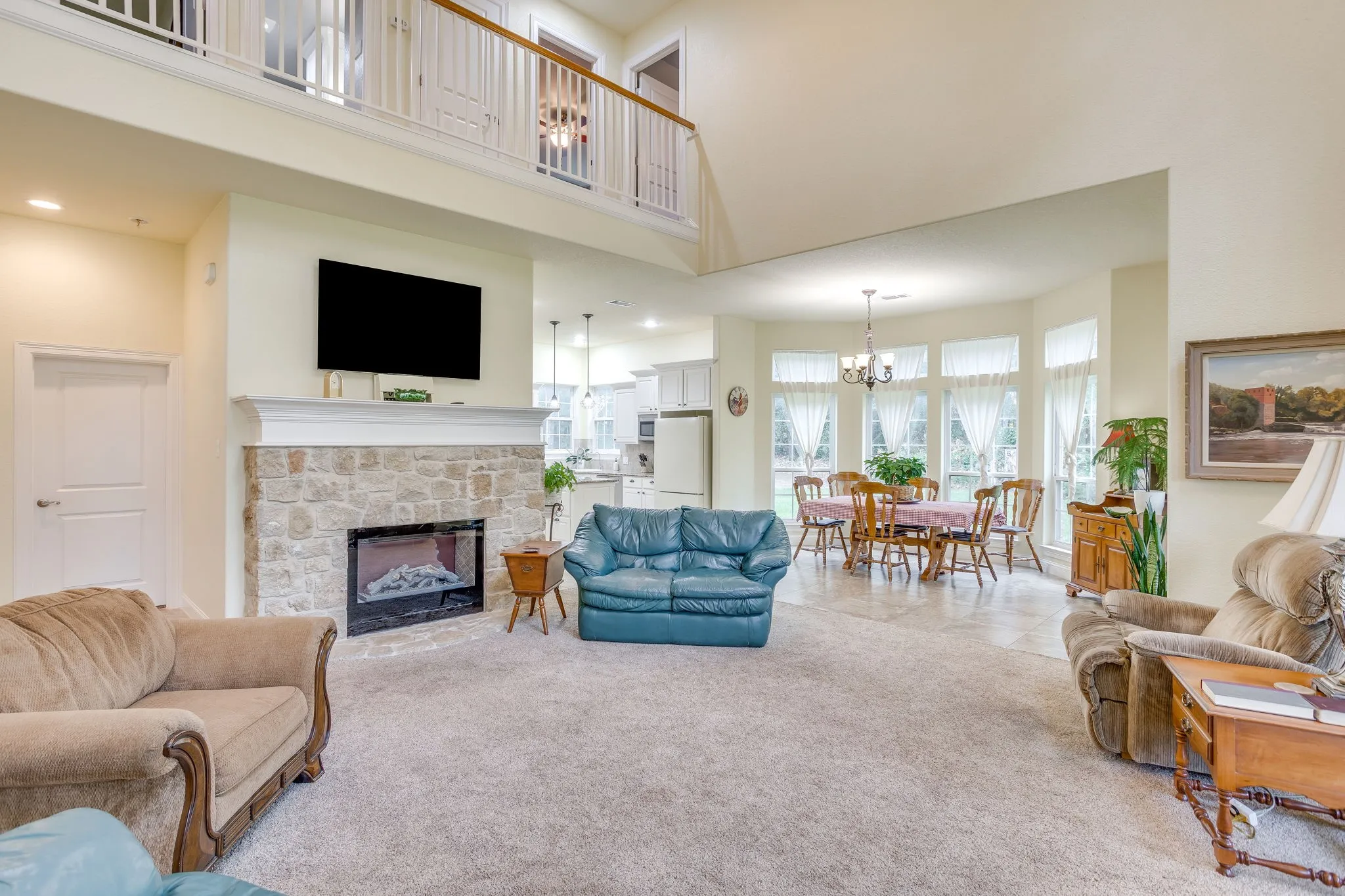 Spacious interior with an open layout, featuring a stone-clad fireplace with a classic mantelpiece
