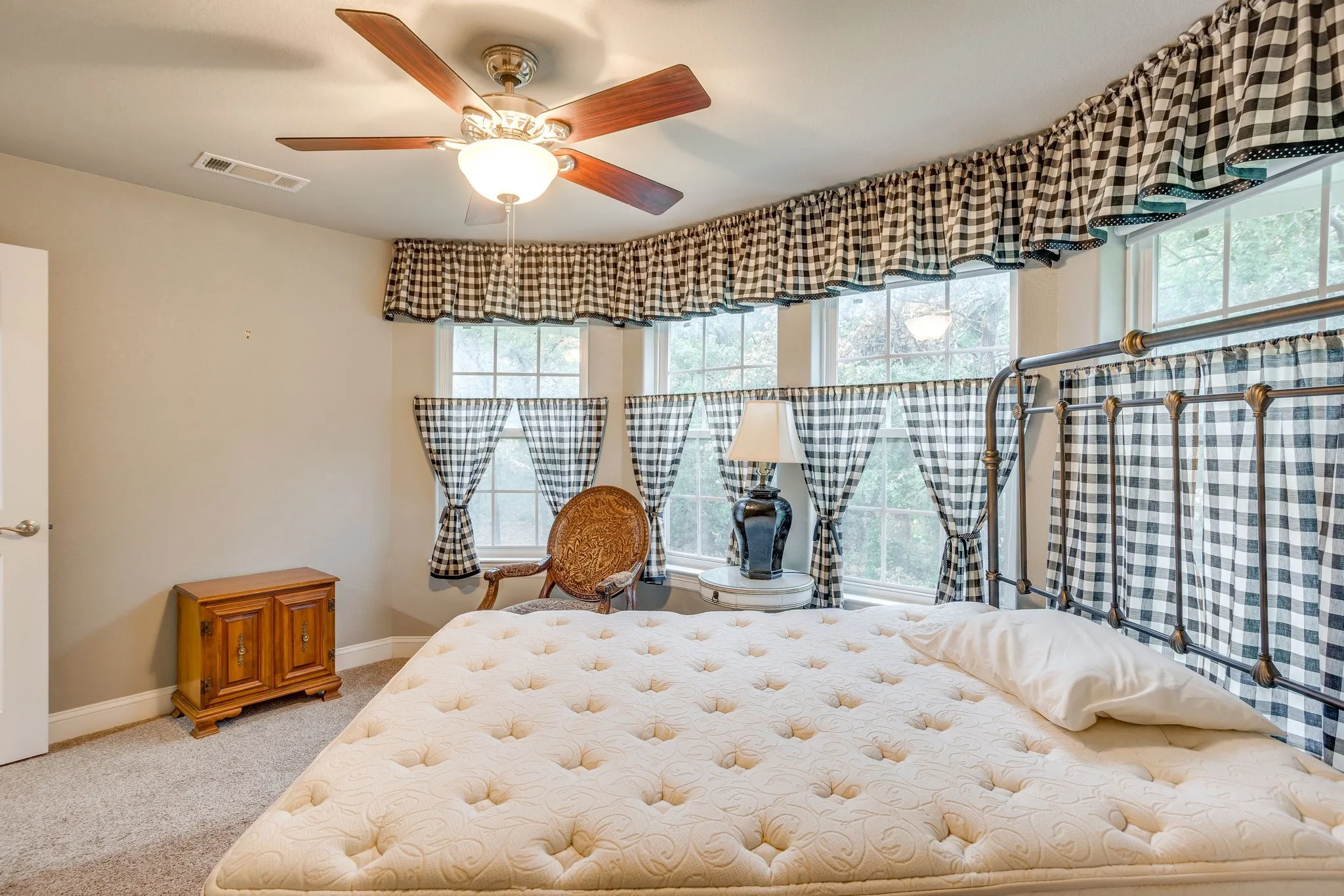 Carpeted interior space featuring a multi-window wall, ceiling fan with integrated lighting, and neutral wall paint