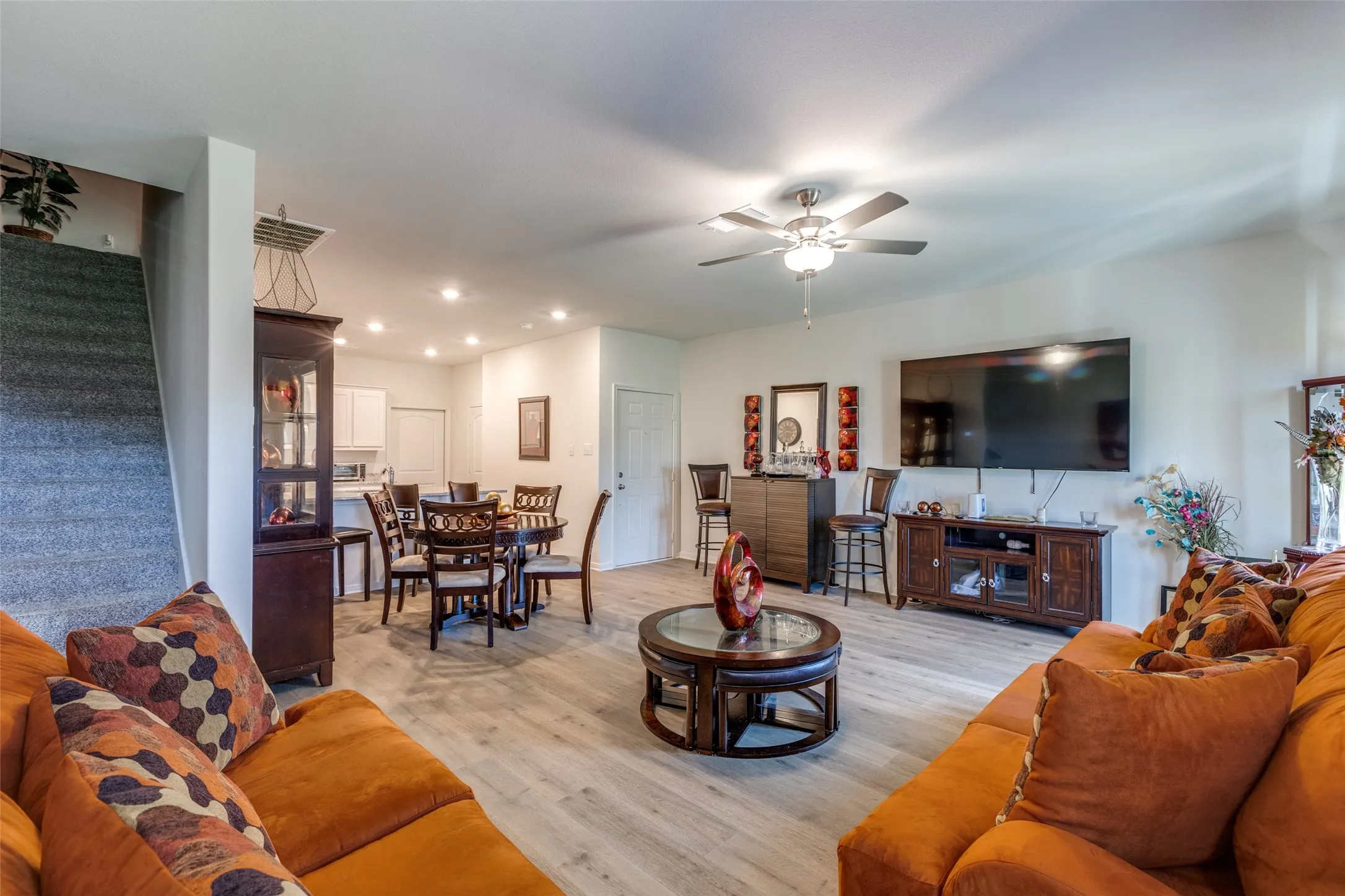 Living room featuring ceiling fan, light wood-style flooring, stairs, and recessed lighting